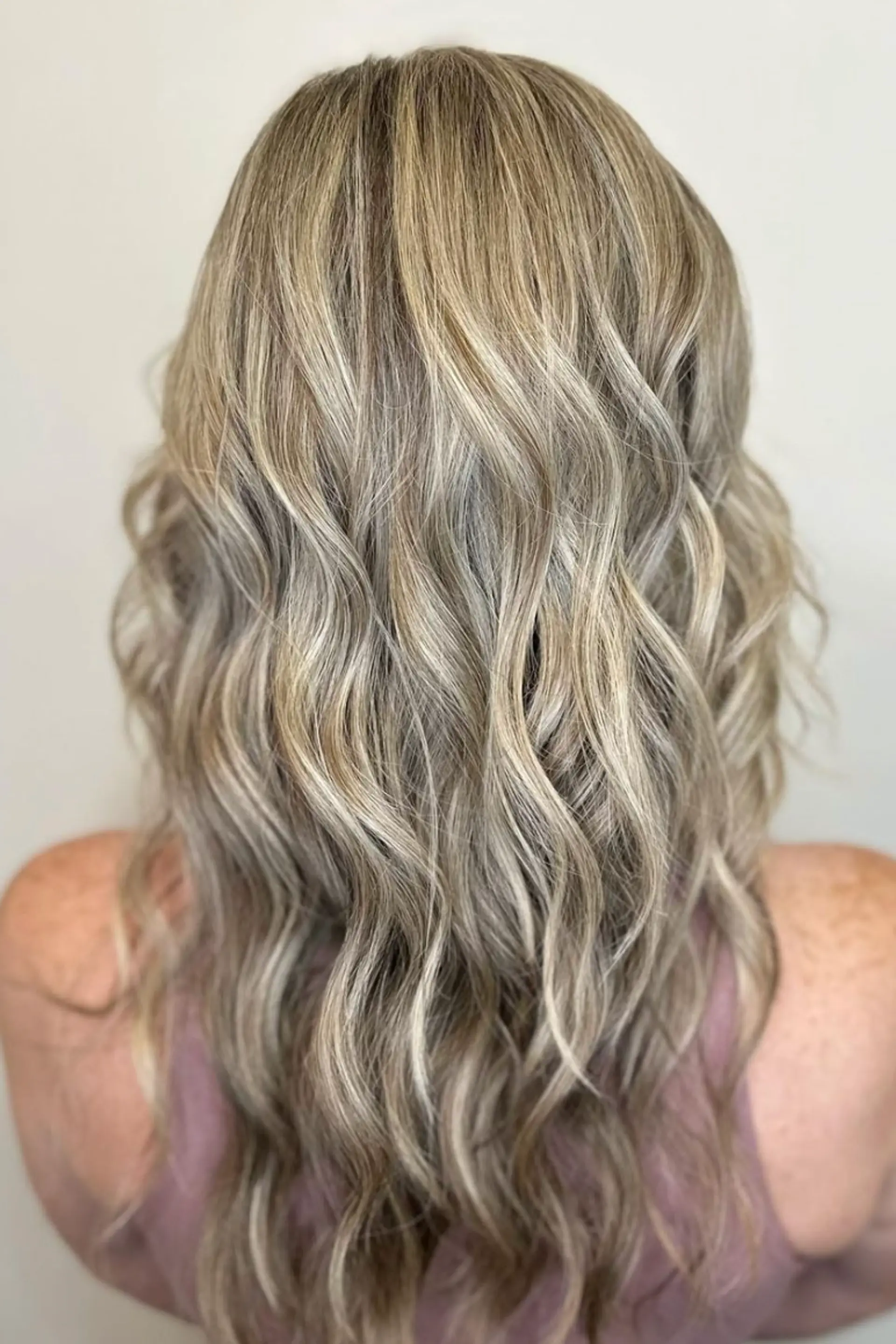 Long, wavy hair with a soft blonde base and honey highlights. The style features subtle waves, a side part, and a layered cut for added volume and movement.

Color by @simabeautynyc
 2