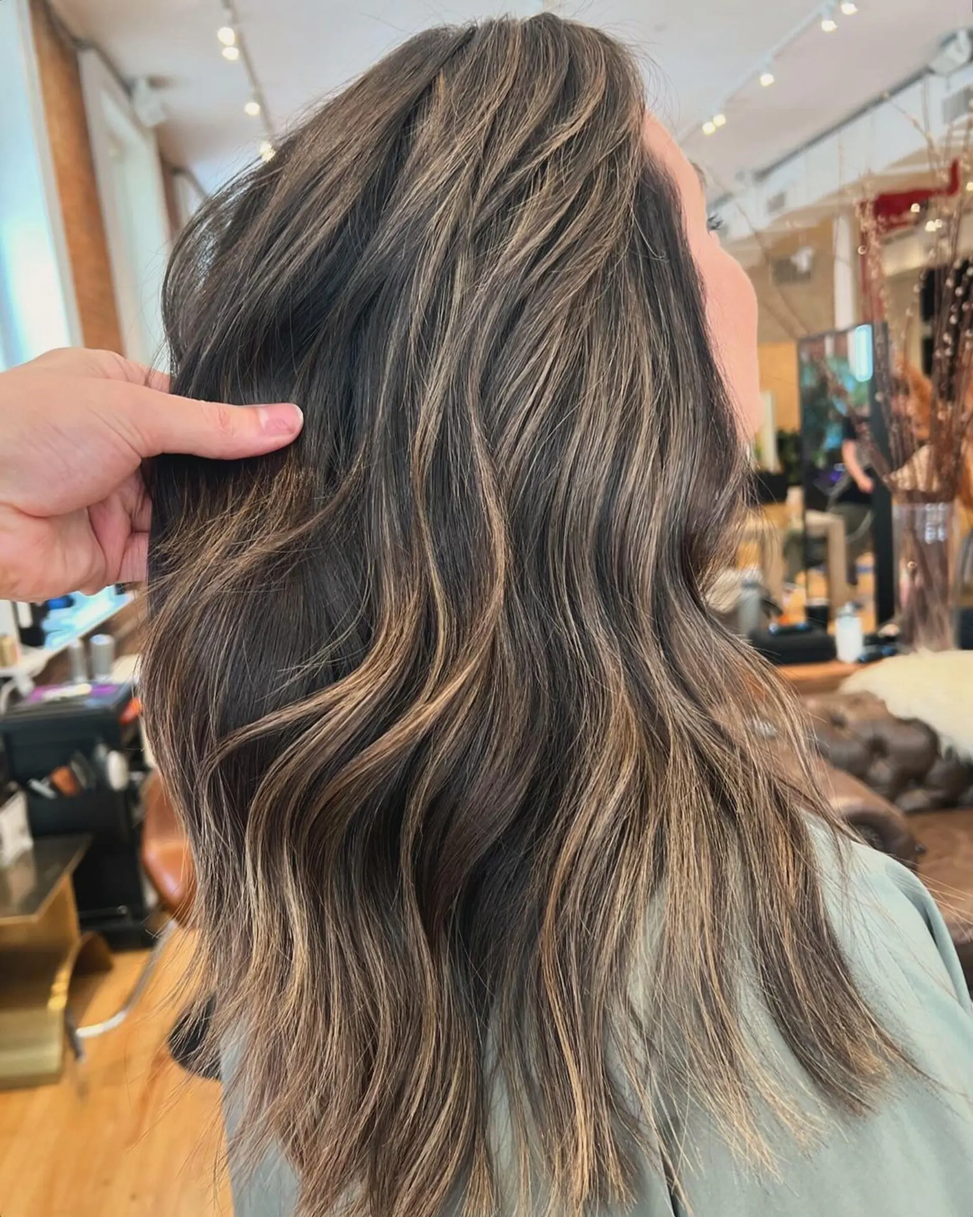 Medium length, wavy texture, brunette with blonde highlights, soft layers. 1