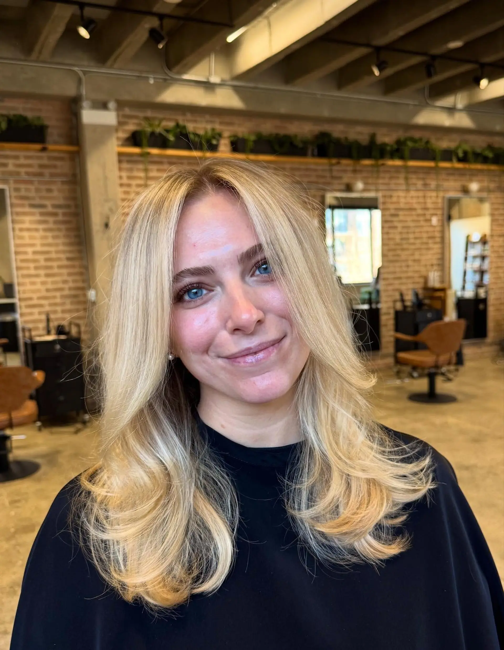 This hairstyle showcases a modern butterfly cut characterized by significant long layers that create a voluminous, bouncy effect, complemented by soft, face-framing layers that blend seamlessly into the length. 1