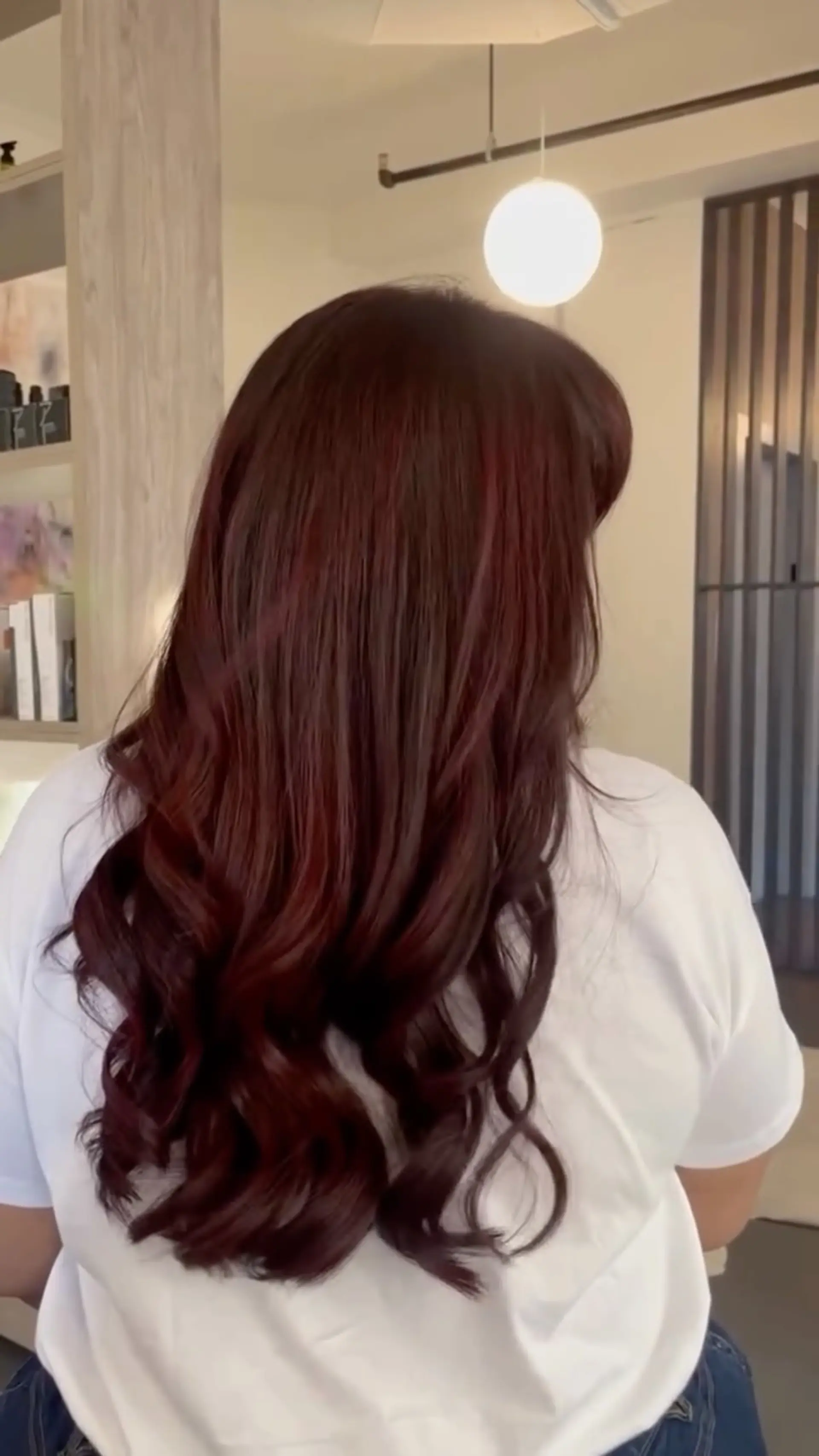 Long cherry red hair styled smooth at the crown transitioning into glossy, bouncy waves at the ends. 1