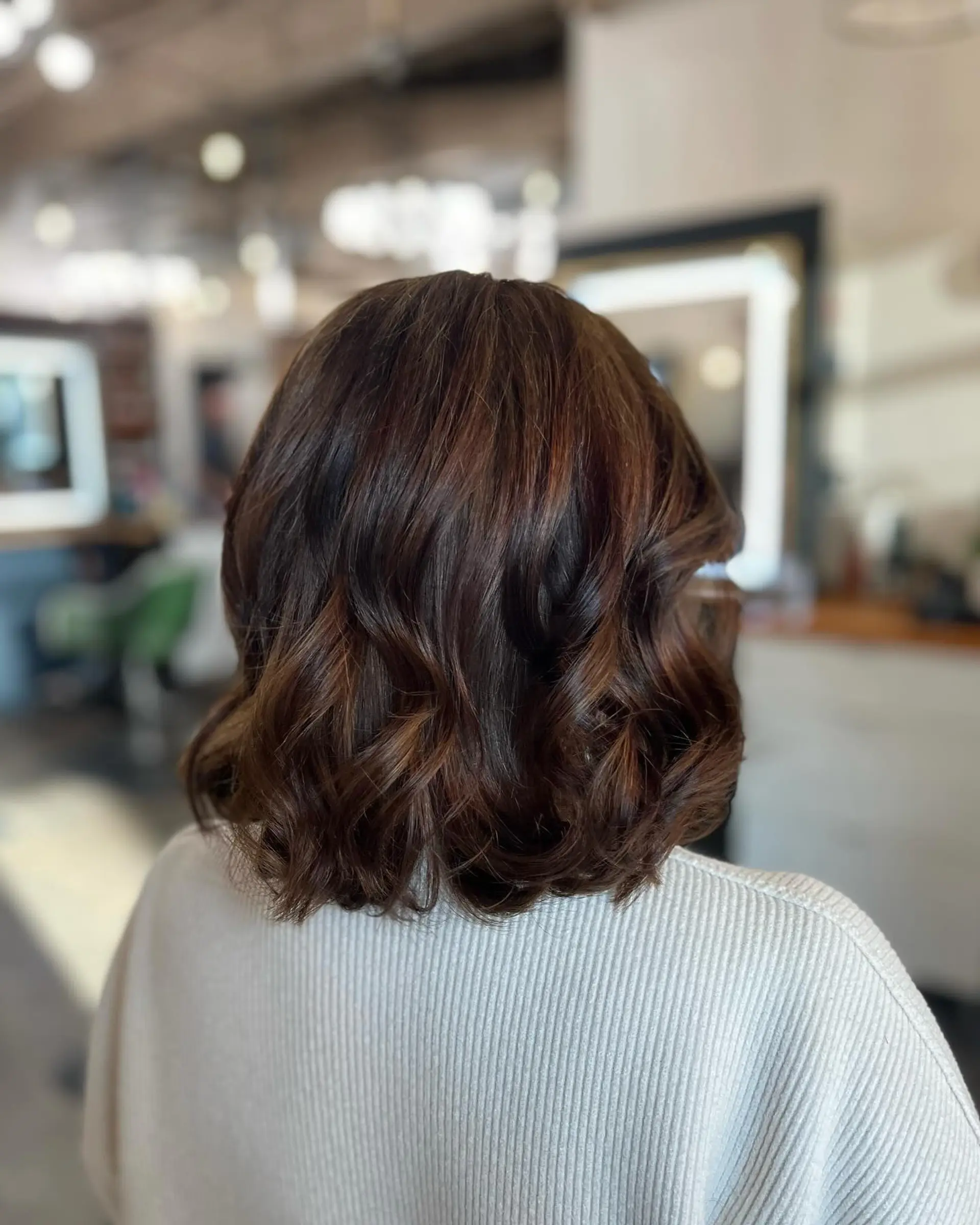 A shoulder-length rich chocolate brunette lob styled into soft, elegant loose waves. 1