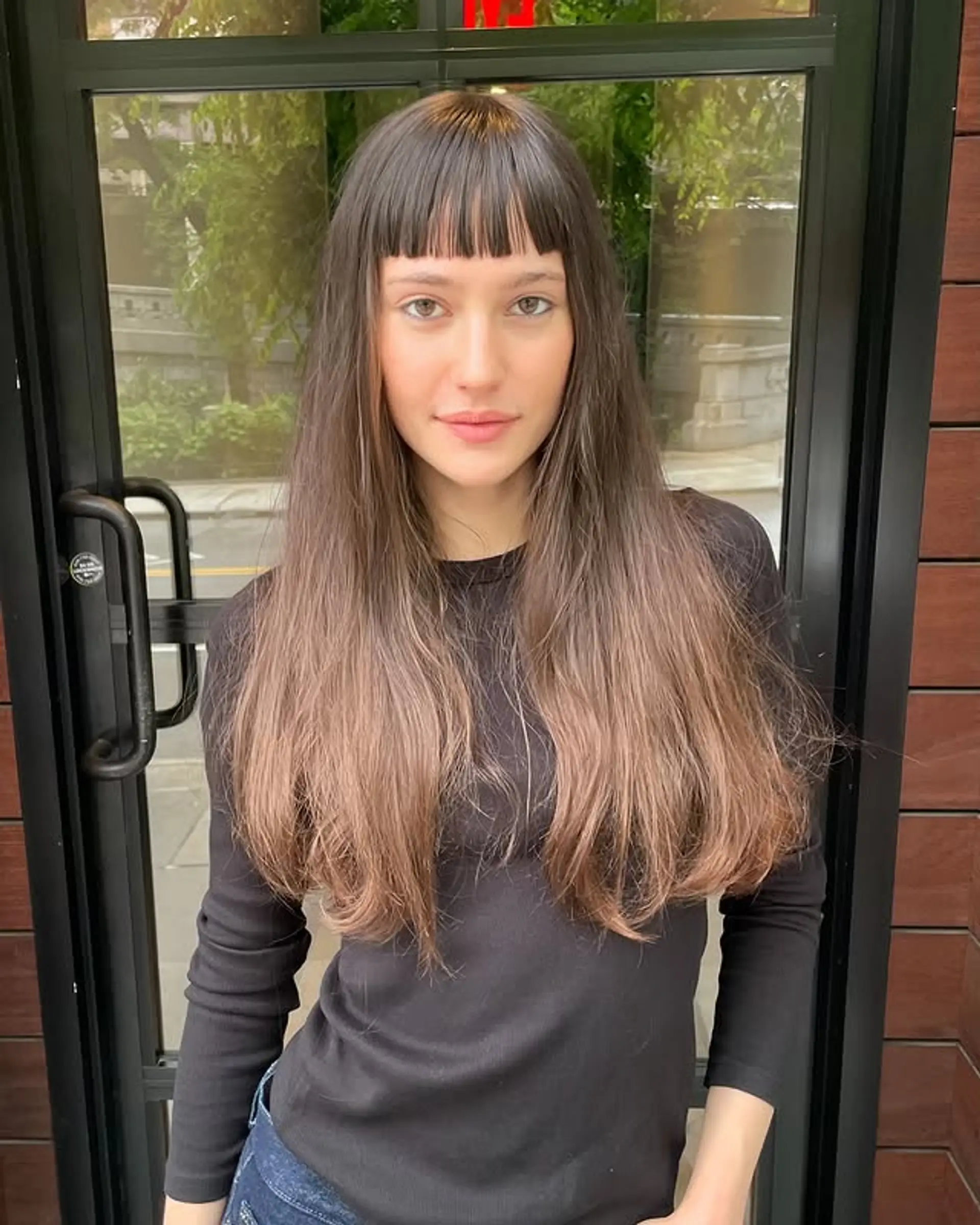 Long layered haircut with straight Bardot bangs. 1