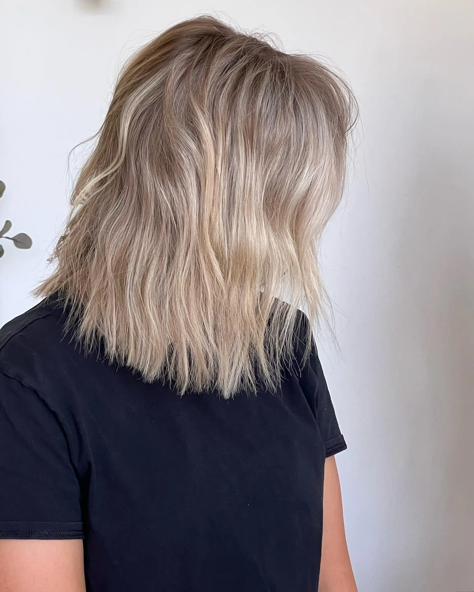 A textured shoulder-length lob featuring dimensional blonde highlights and soft, subtle waves. 1