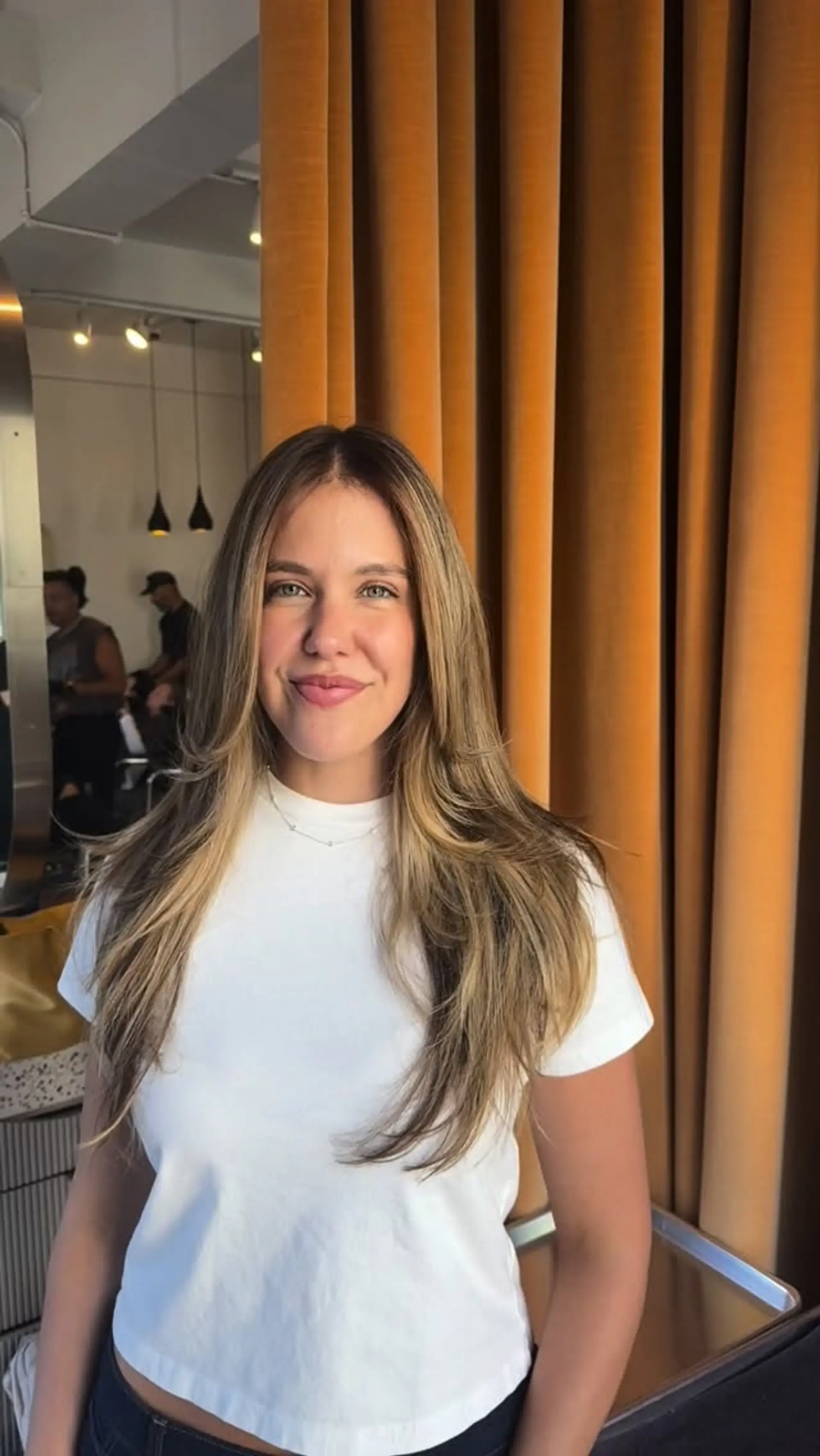 Long layered haircut featuring face-framing layers and a smooth, voluminous blowout with softly curved ends. 1