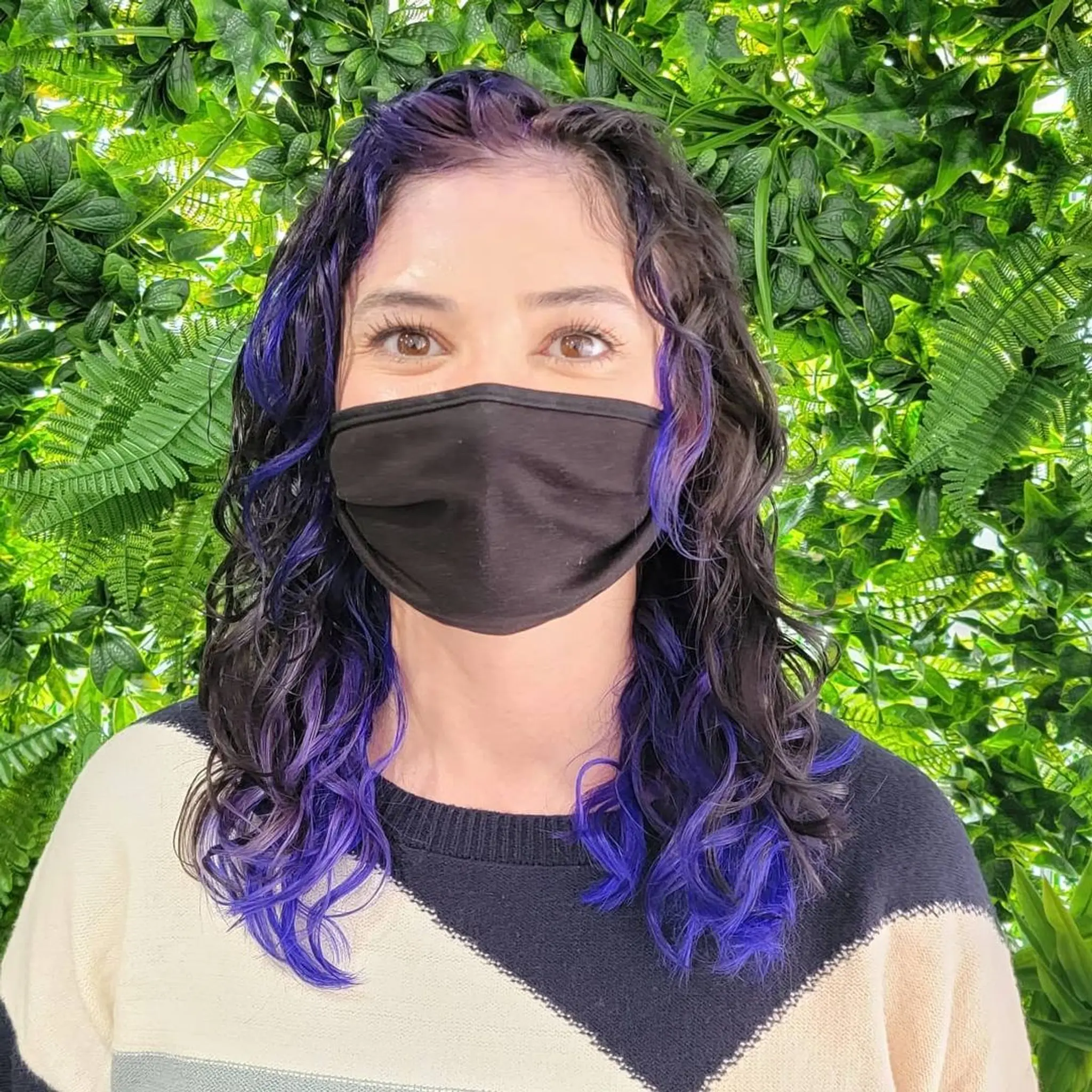 Medium length, curly hair with black base color highlighted by bold purples cascading through the curls and layered tips for added dimension. 4
