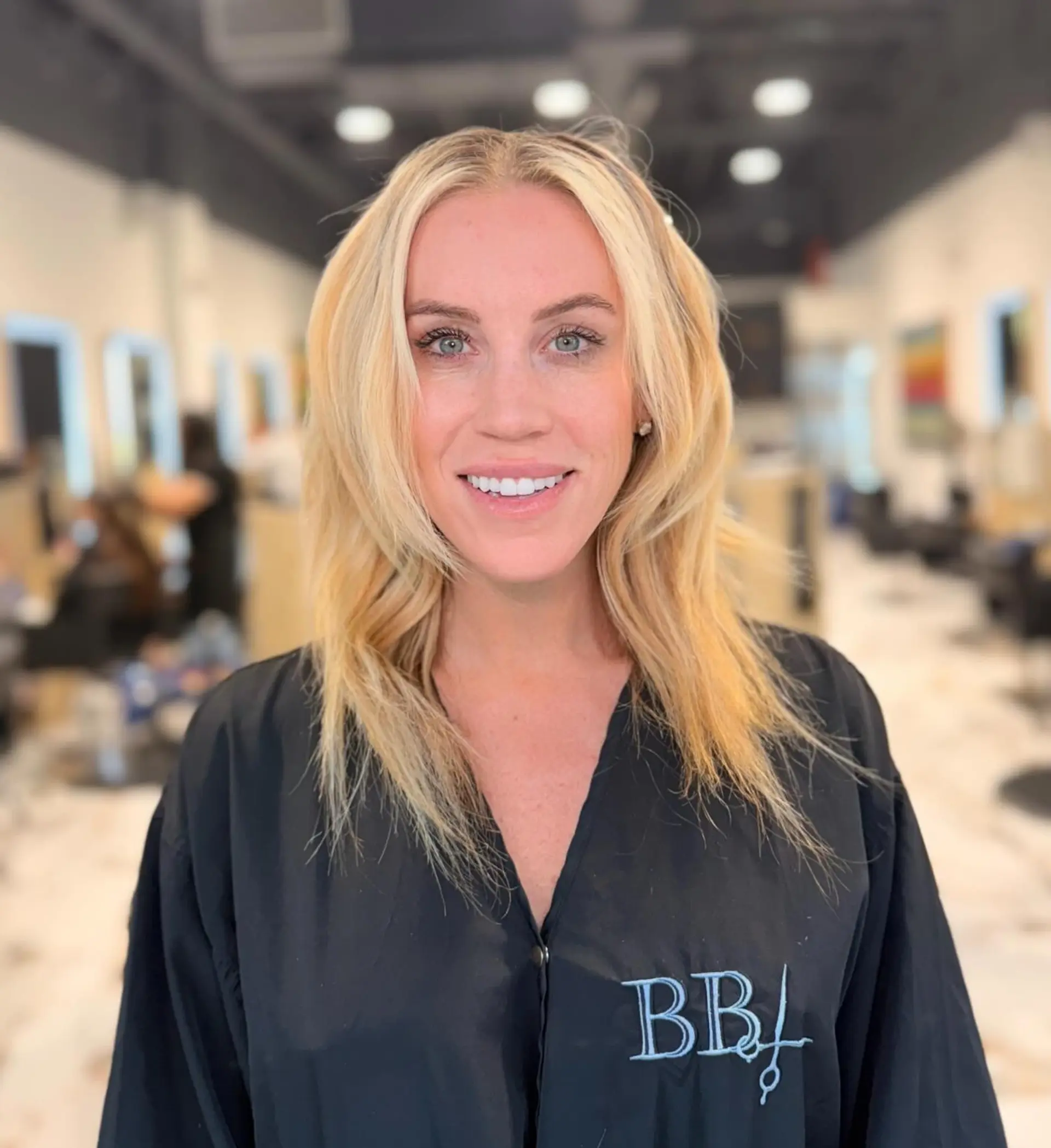 Collarbone-length bright blonde hair enhanced with extensions and styled with soft face-framing layers. 1