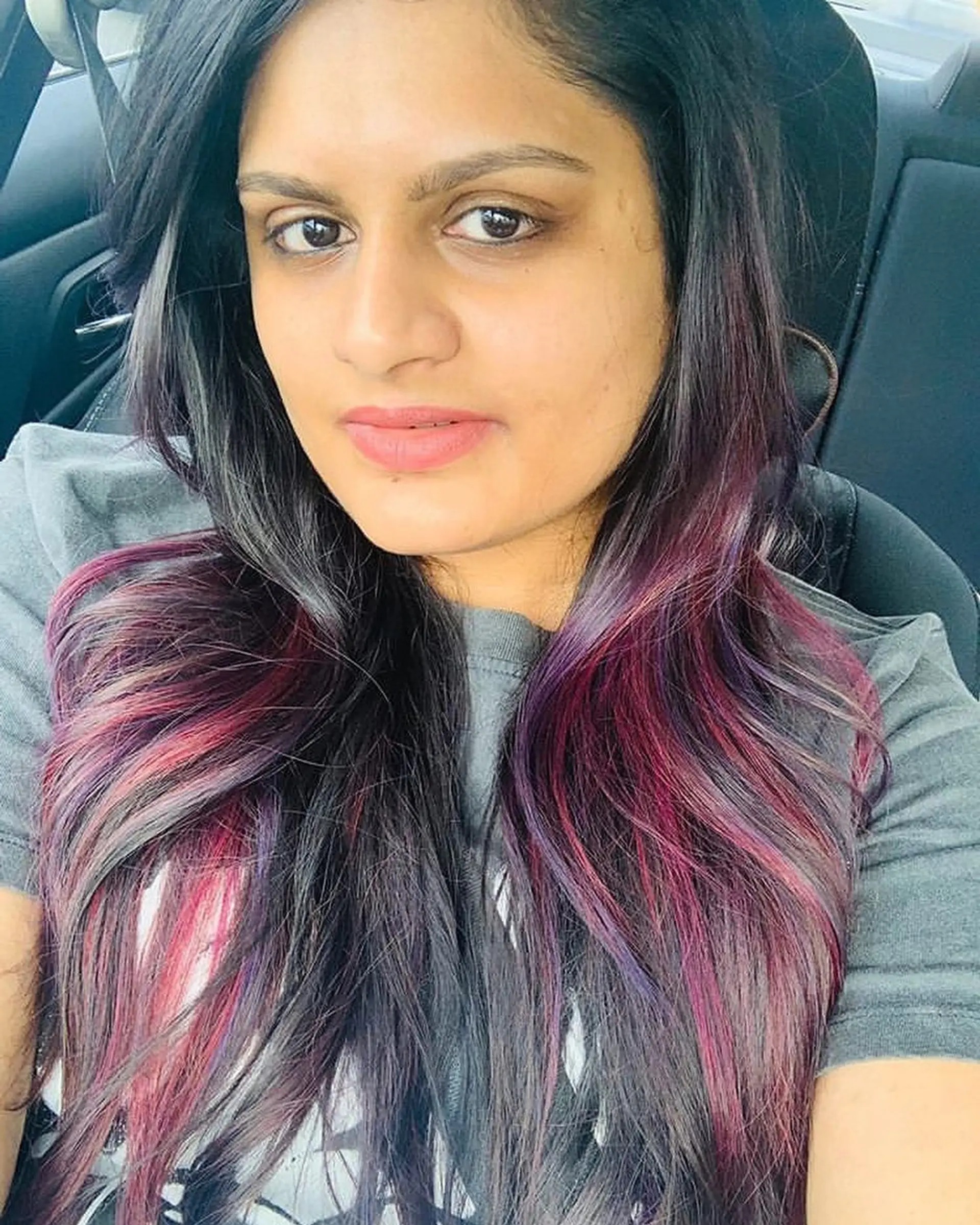 Long layered hair with dimensional highlights of purple and pink. 1