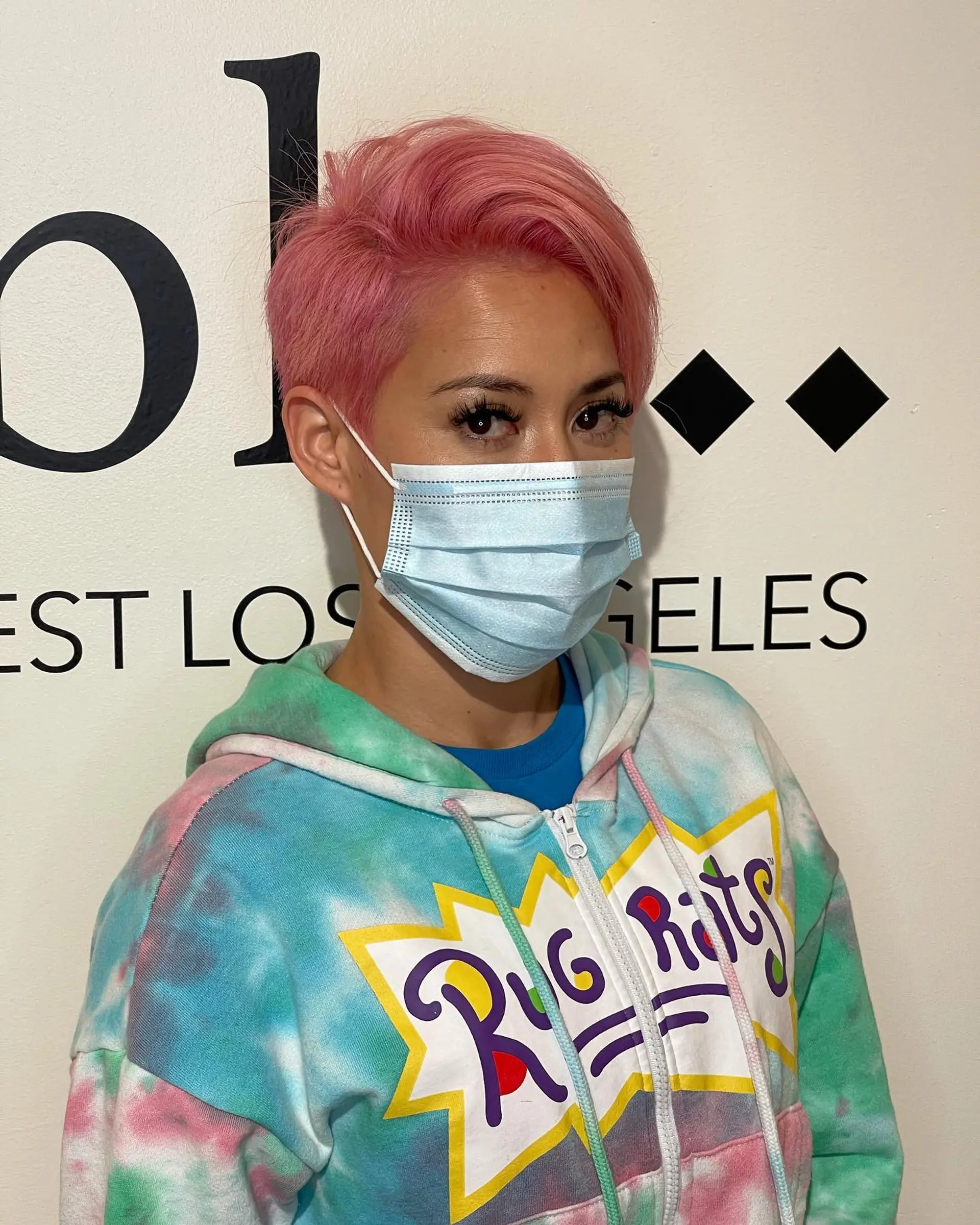 A tapered, side-swept pixie haircut colored in a bright bubblegum pink with textured volume on top. 1