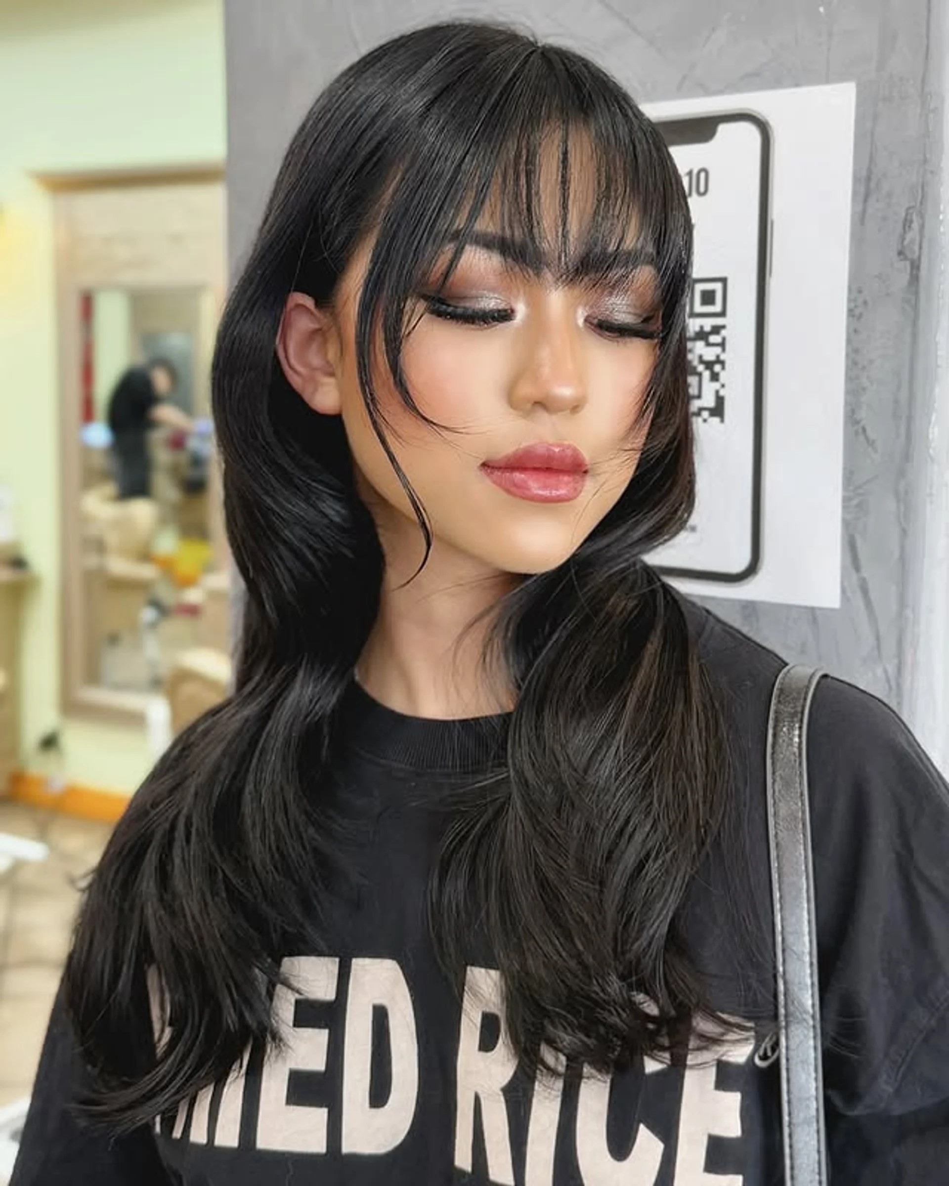 Sleek medium-length hairstyle with soft layers and wispy curtain bangs in dark brown to black color - Preview 2