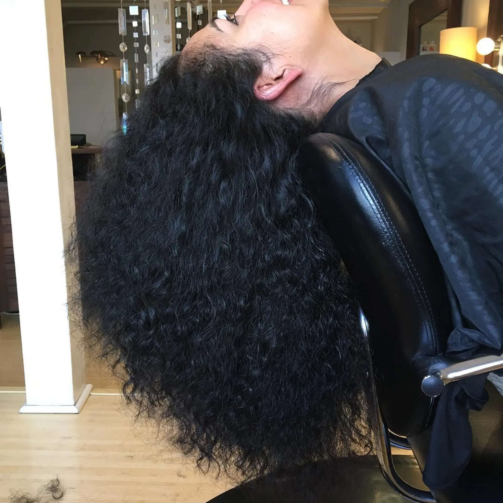 A voluminous, full-bodied long curly hairstyle featuring textured natural ringlets and enhanced shape. 1