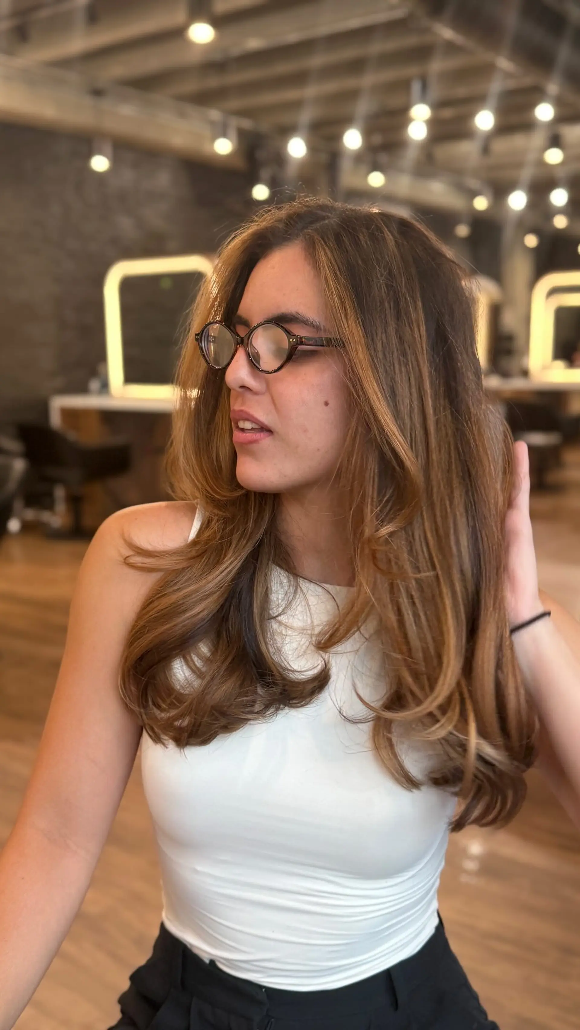 Long layered warm brown hair with caramel highlights styled in a voluminous, soft blowout. 1