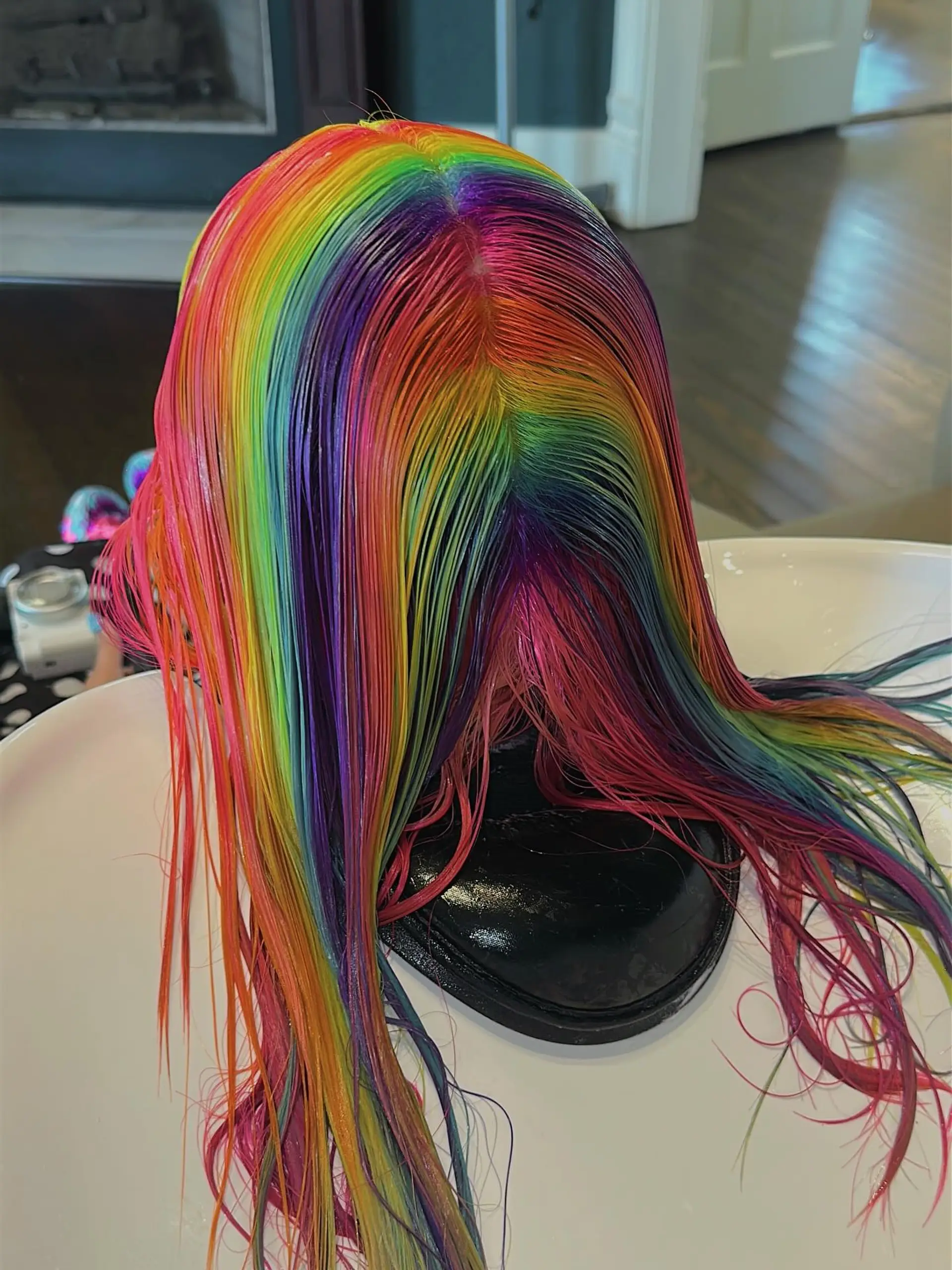 A medium-length hairstyle with vibrant rainbow coloring, characterized by sharp blunt bangs and soft face-framing layers that create a contemporary shag silhouette. 5