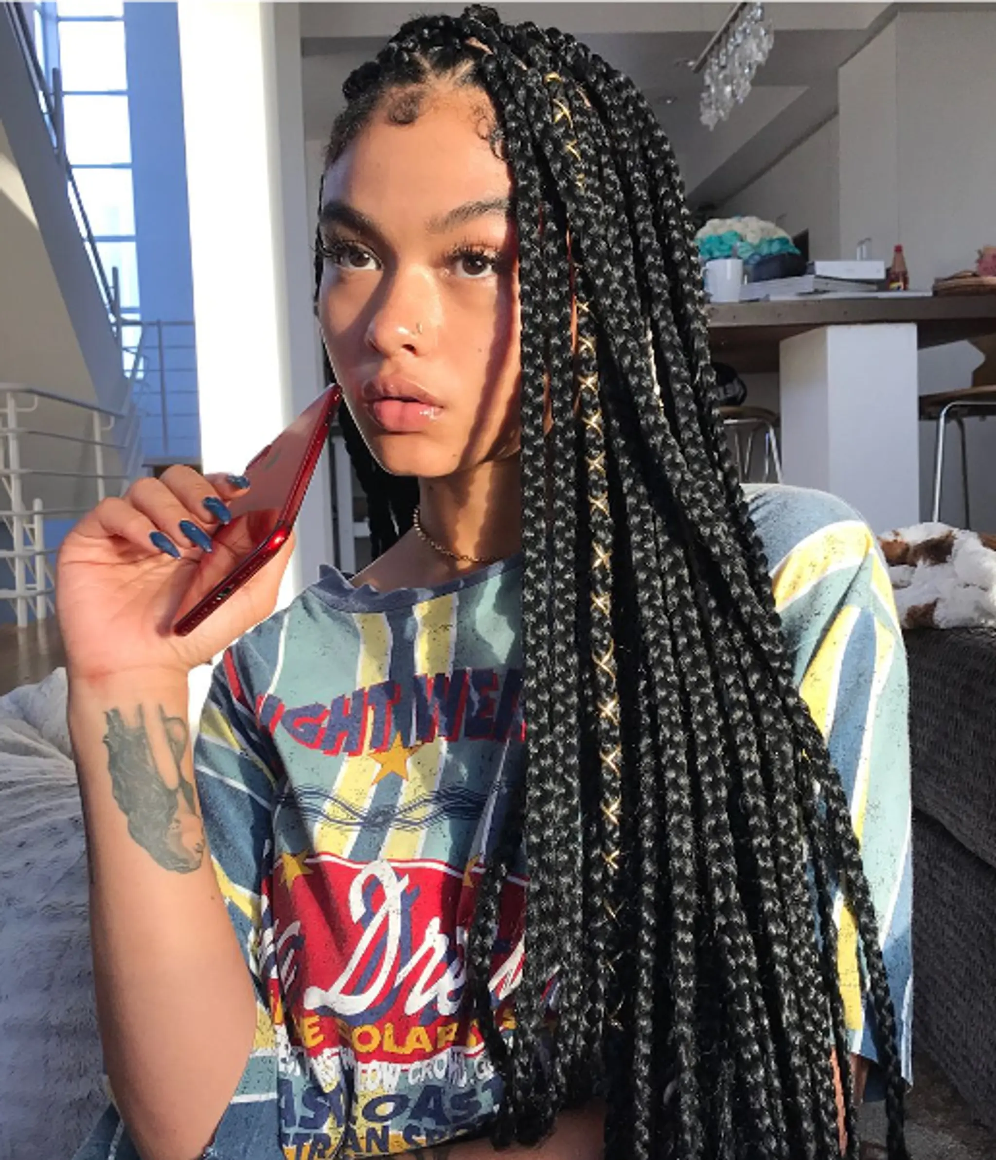 Intricately styled box braids with gold thread accents, offering a stylish and elegant appearance.