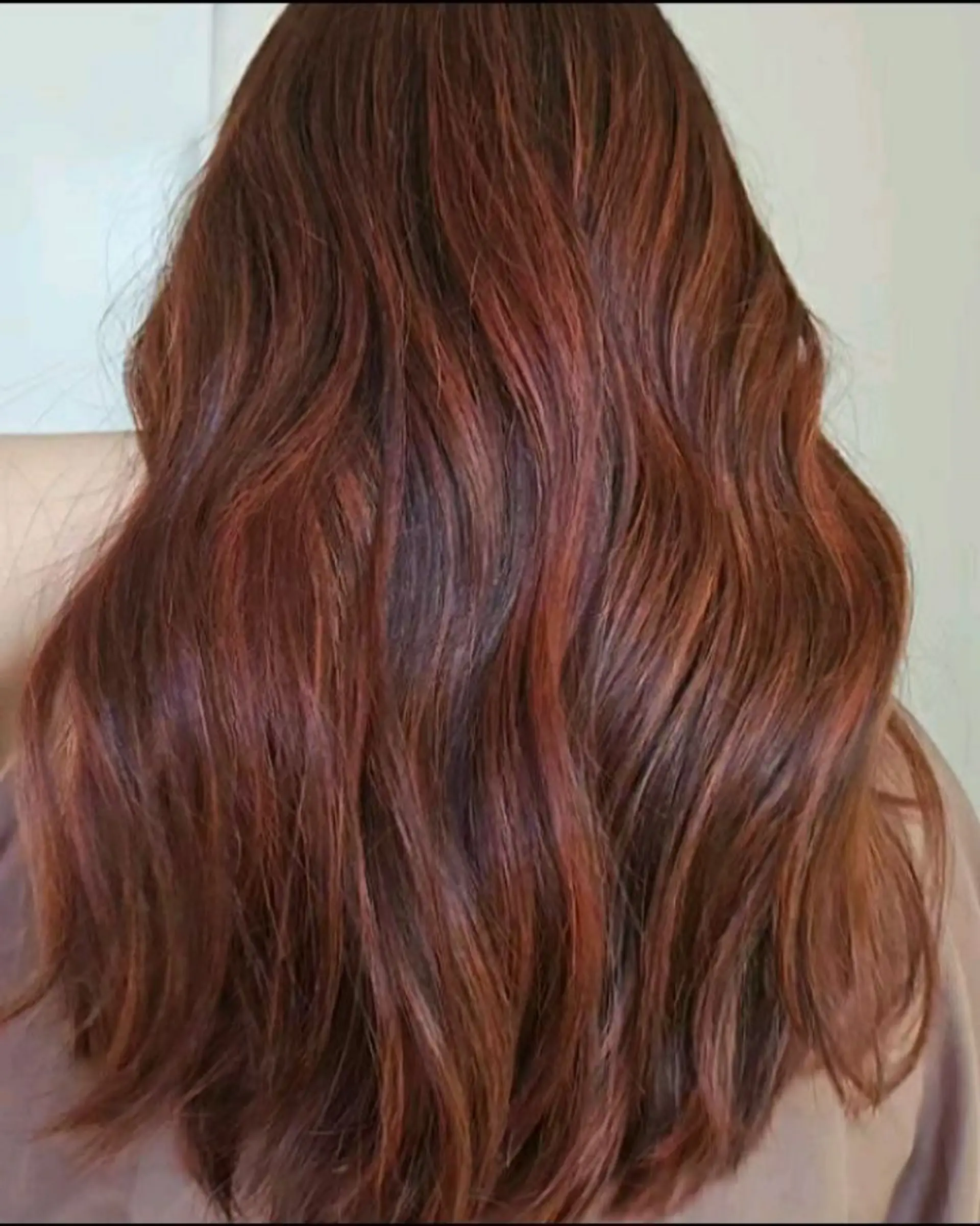 Rich auburn and copper dimensional balayage styled in soft, flowing waves. 1