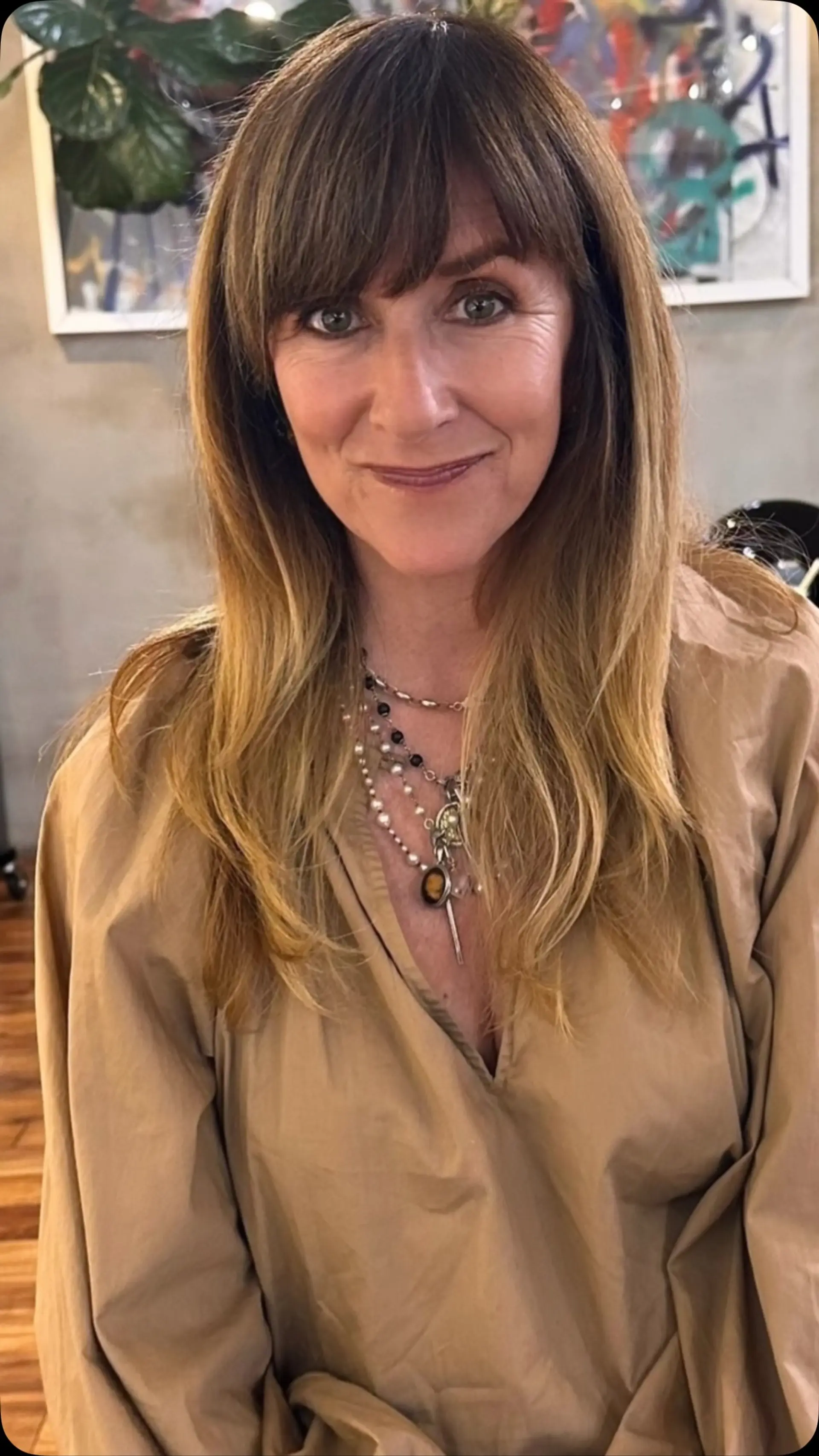 A long layered haircut paired with a full textured fringe and styled with a smooth, soft blowout. 1