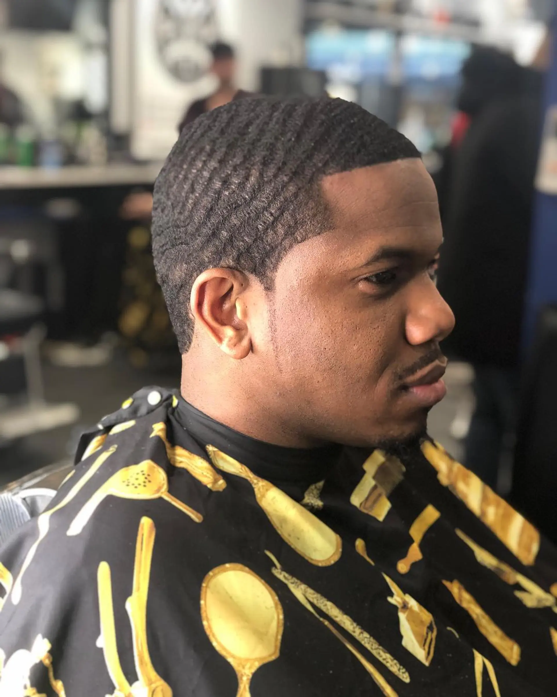 Very short brushed 360 wave pattern with a sharp, crisp line up and subtle sideburn taper. 1