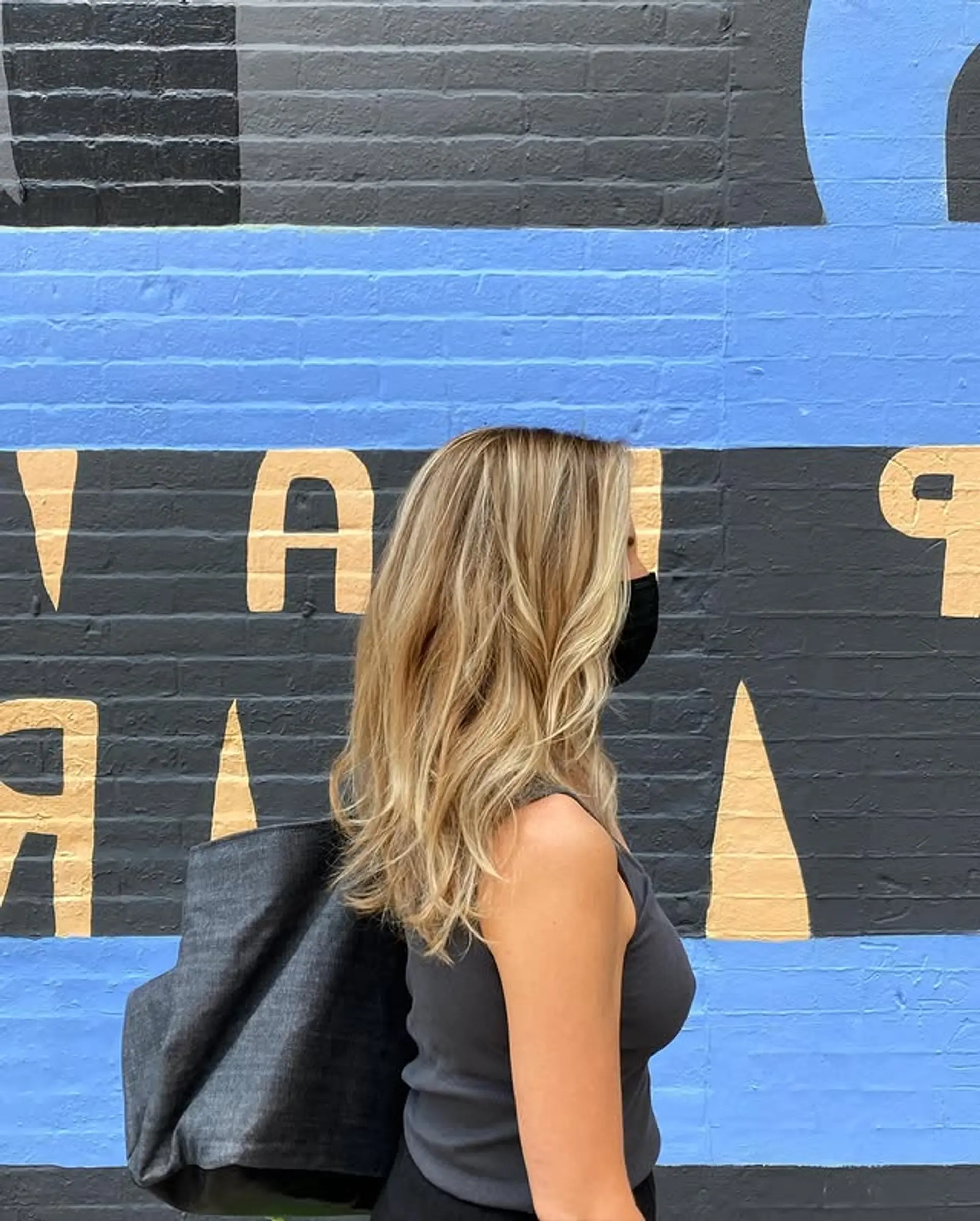 A medium-length wavy hairstyle with blonde balayage highlights styled into loose beachy waves. 1