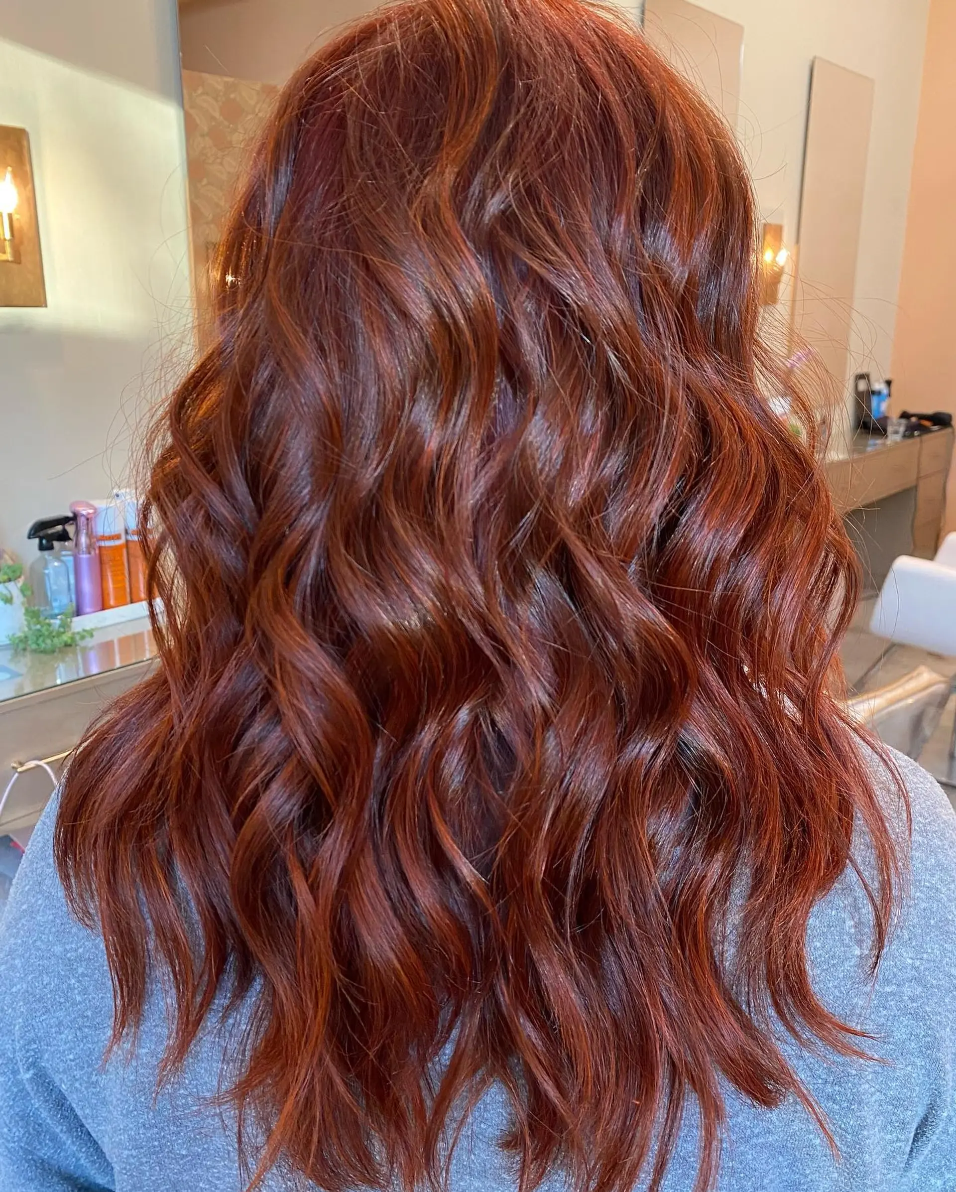 Vibrant, glossy auburn red long hair styled into loose, effortless waves. 1
