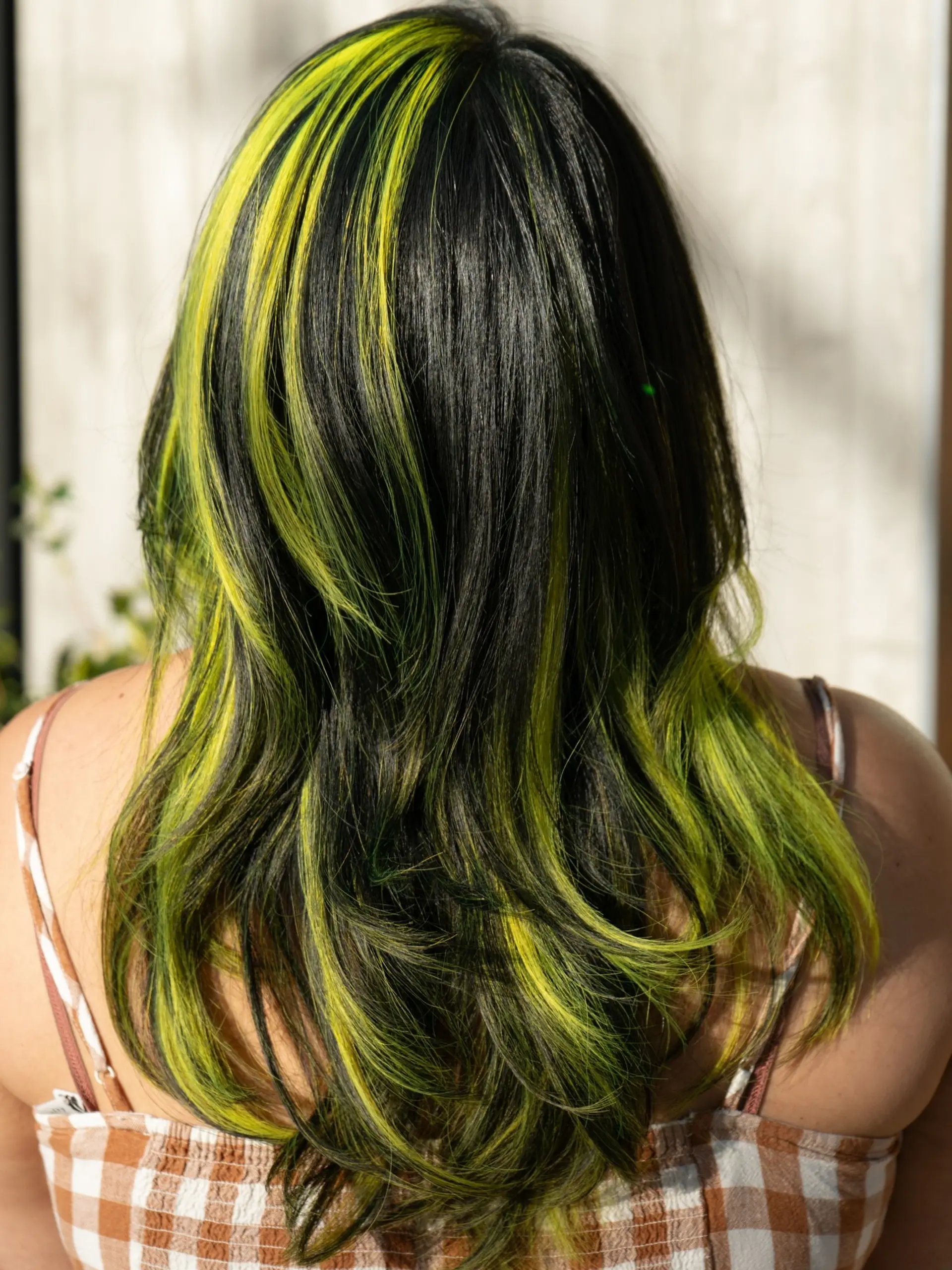 Long dark layered hair featuring vibrant lime green vivid color blocking panels. 1