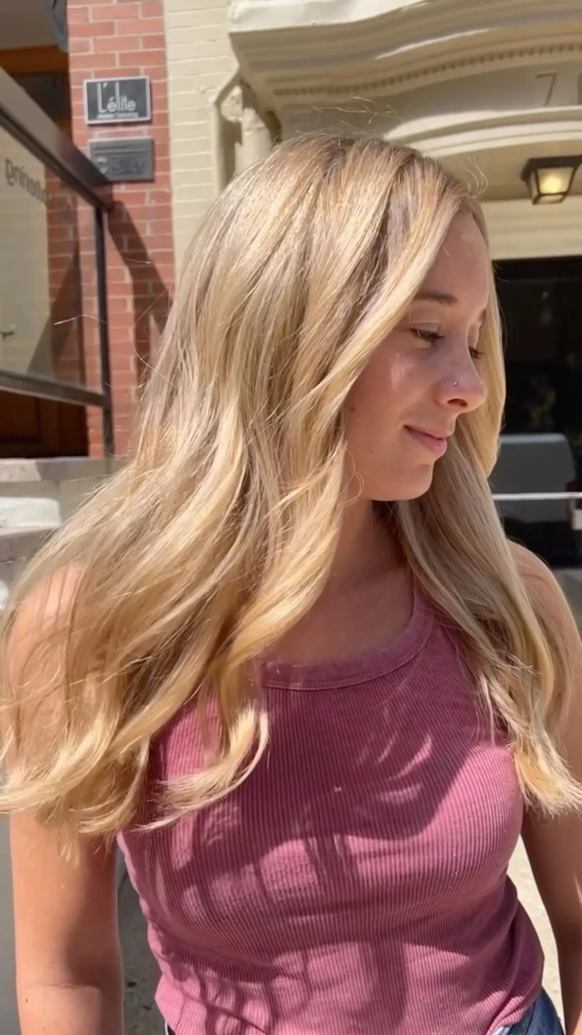 Long buttery blonde hair styled with soft, flowing waves and natural face-framing layers. 1