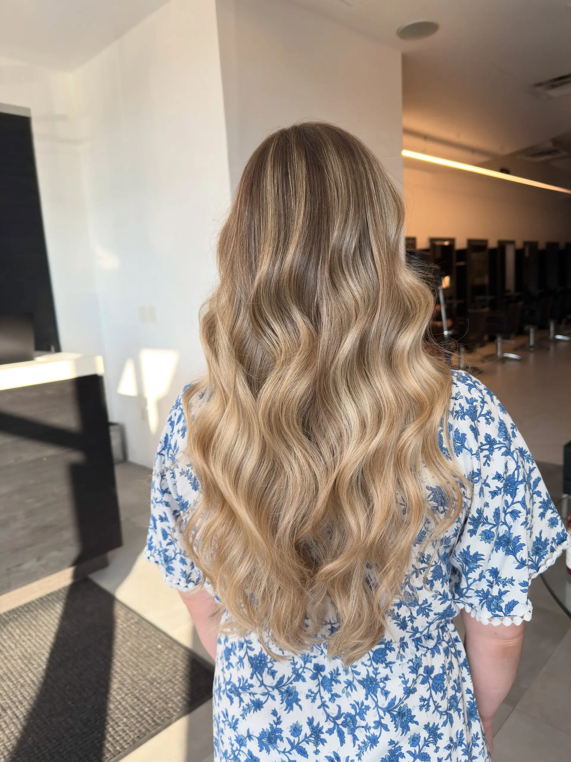 Long, dimensional blonde balayage styled into voluminous, loose flowing waves. 1