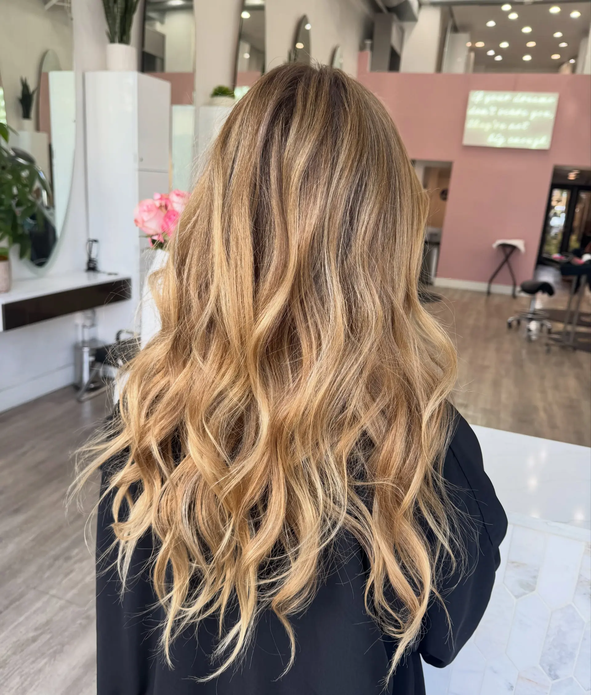 Long bronde hair featuring sun-kissed dimensional highlights styled into loose, flowing beach waves. 1