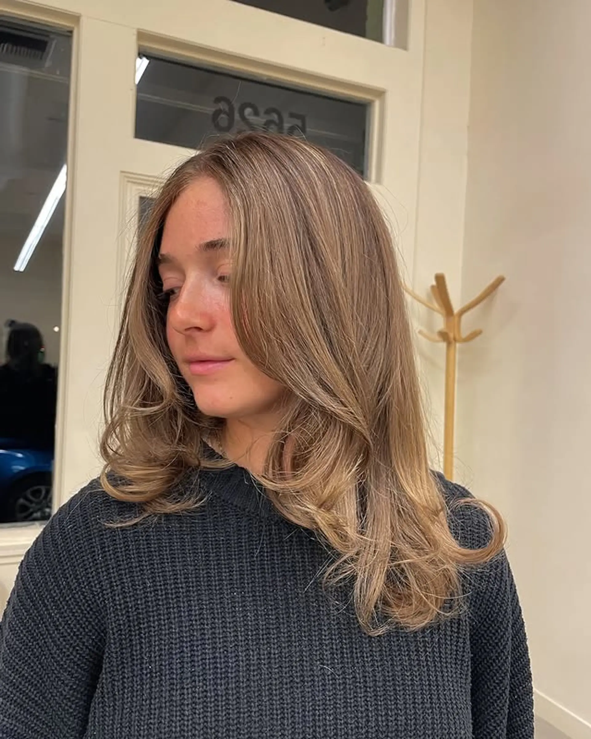 A medium-length layered haircut with caramel highlights and a soft, wavy finish. 1