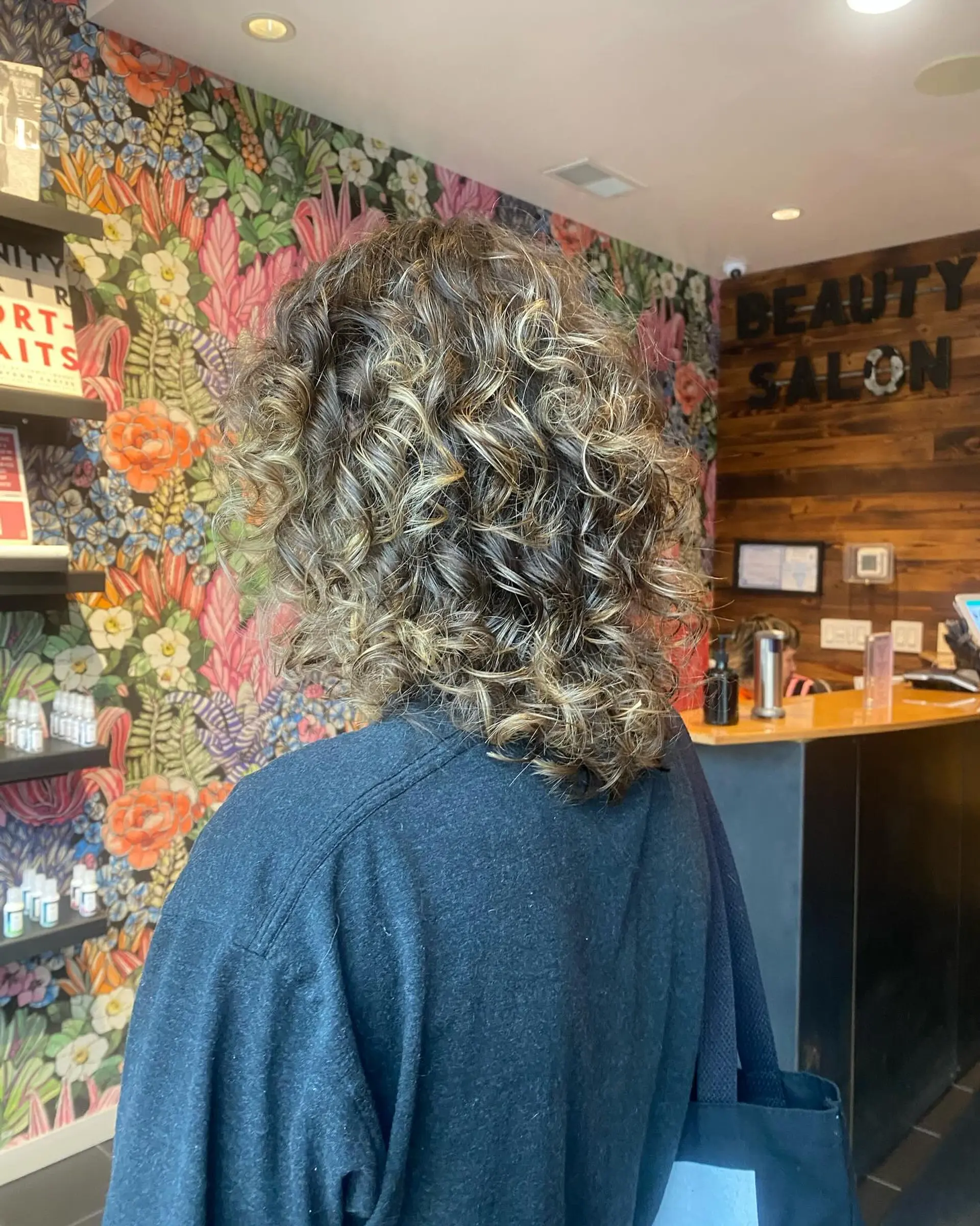 A bouncy, shoulder-length curly hairstyle with a mix of blonde and brown tones for a dimensional look. 1