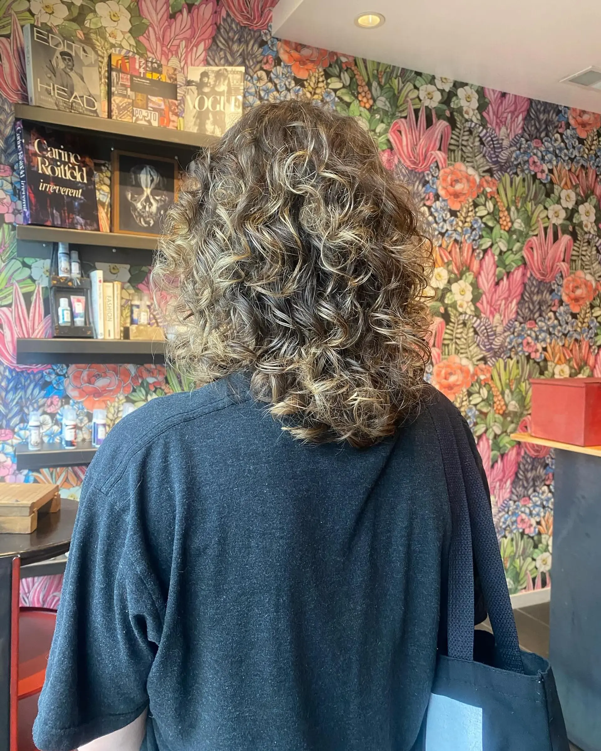 A bouncy, shoulder-length curly hairstyle with a mix of blonde and brown tones for a dimensional look. 2