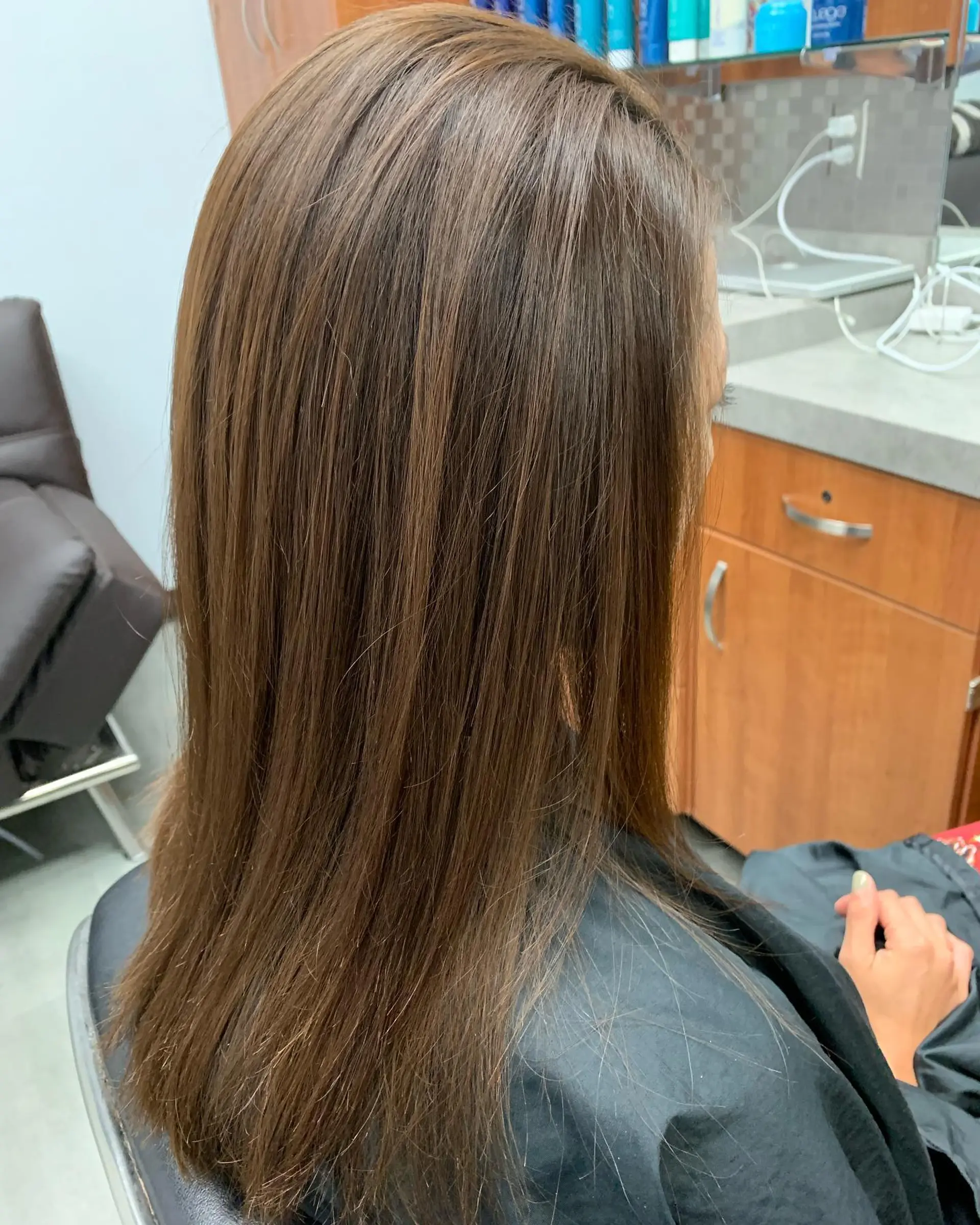 Long, glossy brown hair styled super straight, sleek, and smooth following a Brazilian Blowout treatment. 1