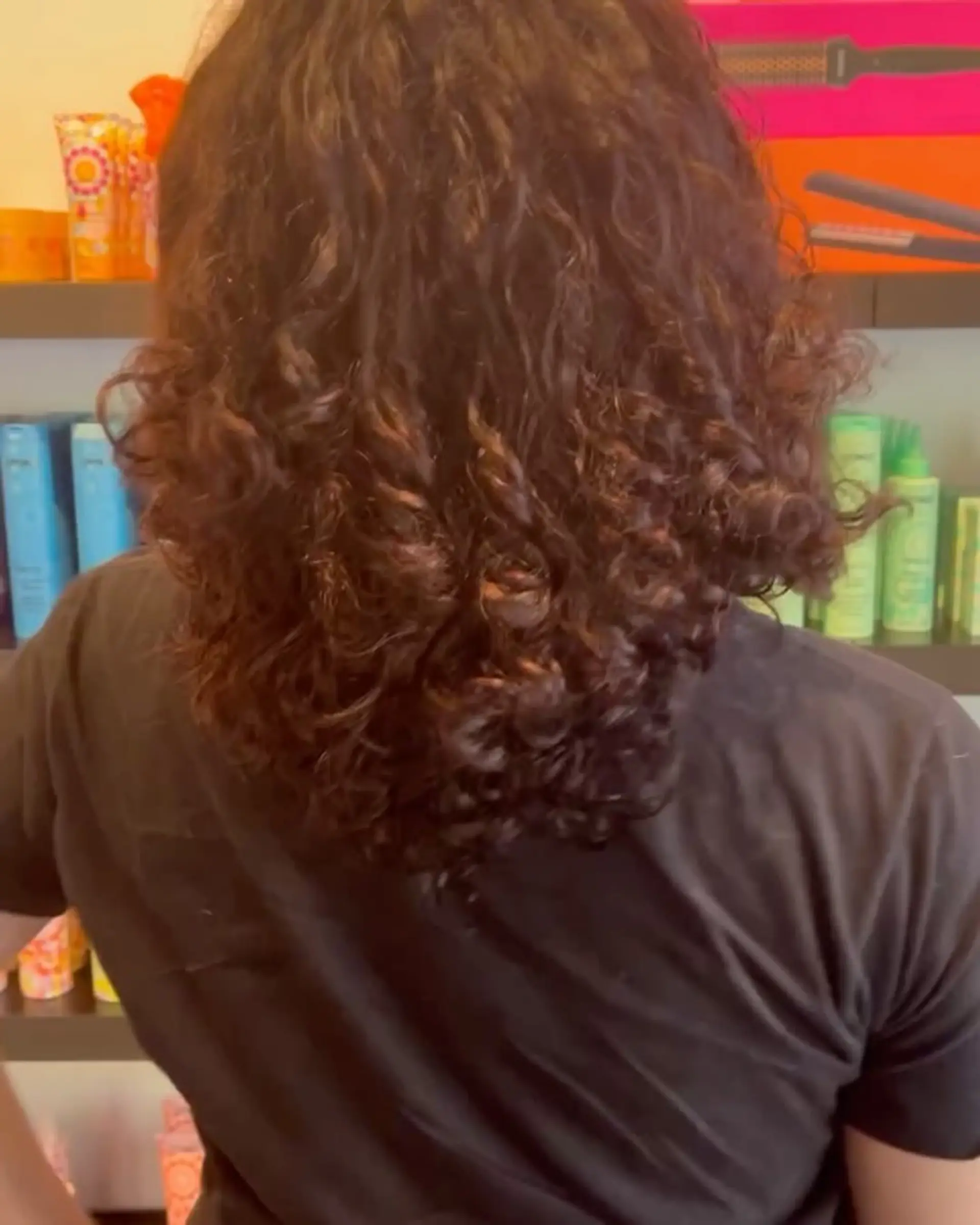 Medium-length, defined natural curls colored in a rich chocolate brunette tone. 1