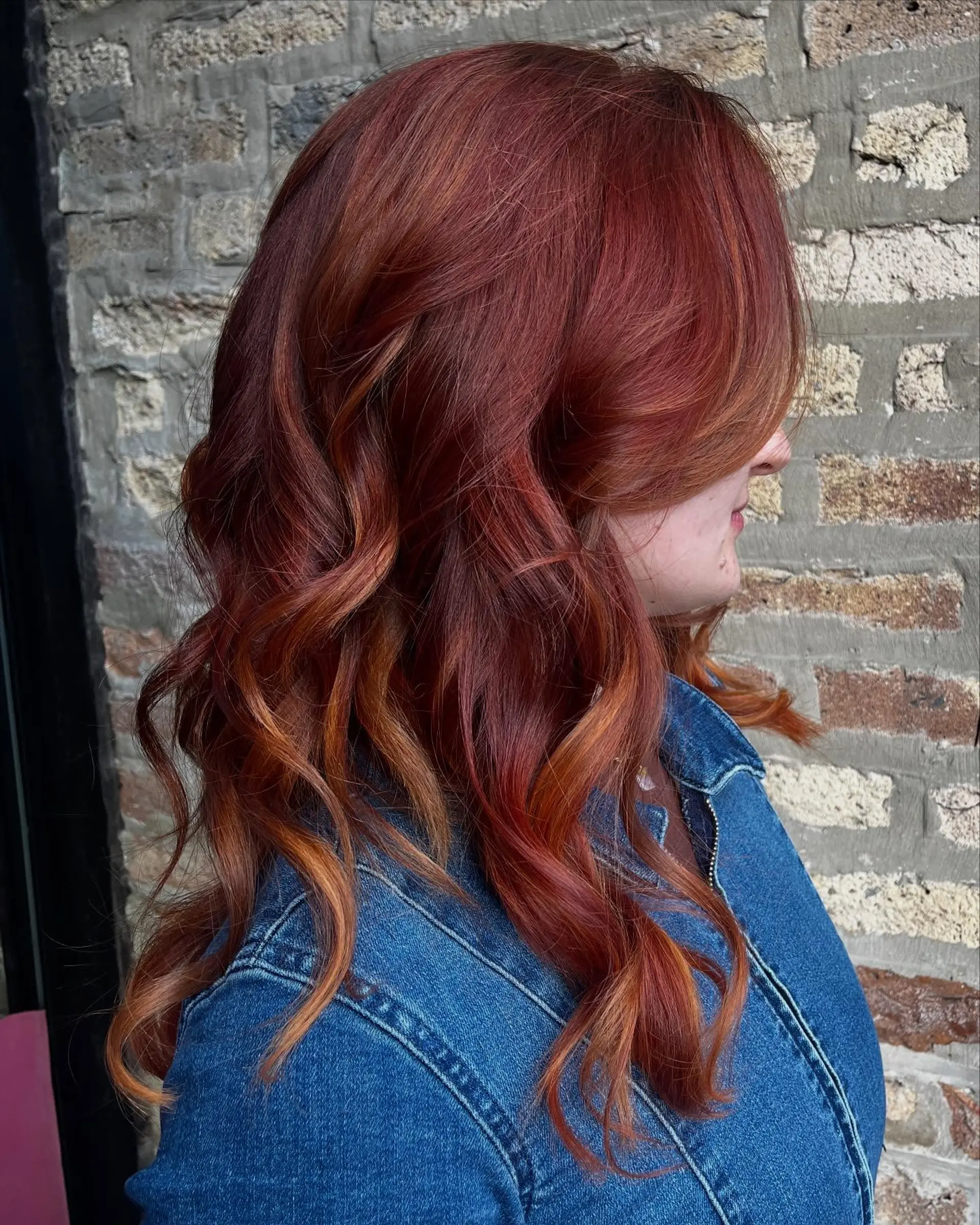 Medium-length wavy hairstyle with warm copper tones and face-framing layers. 1