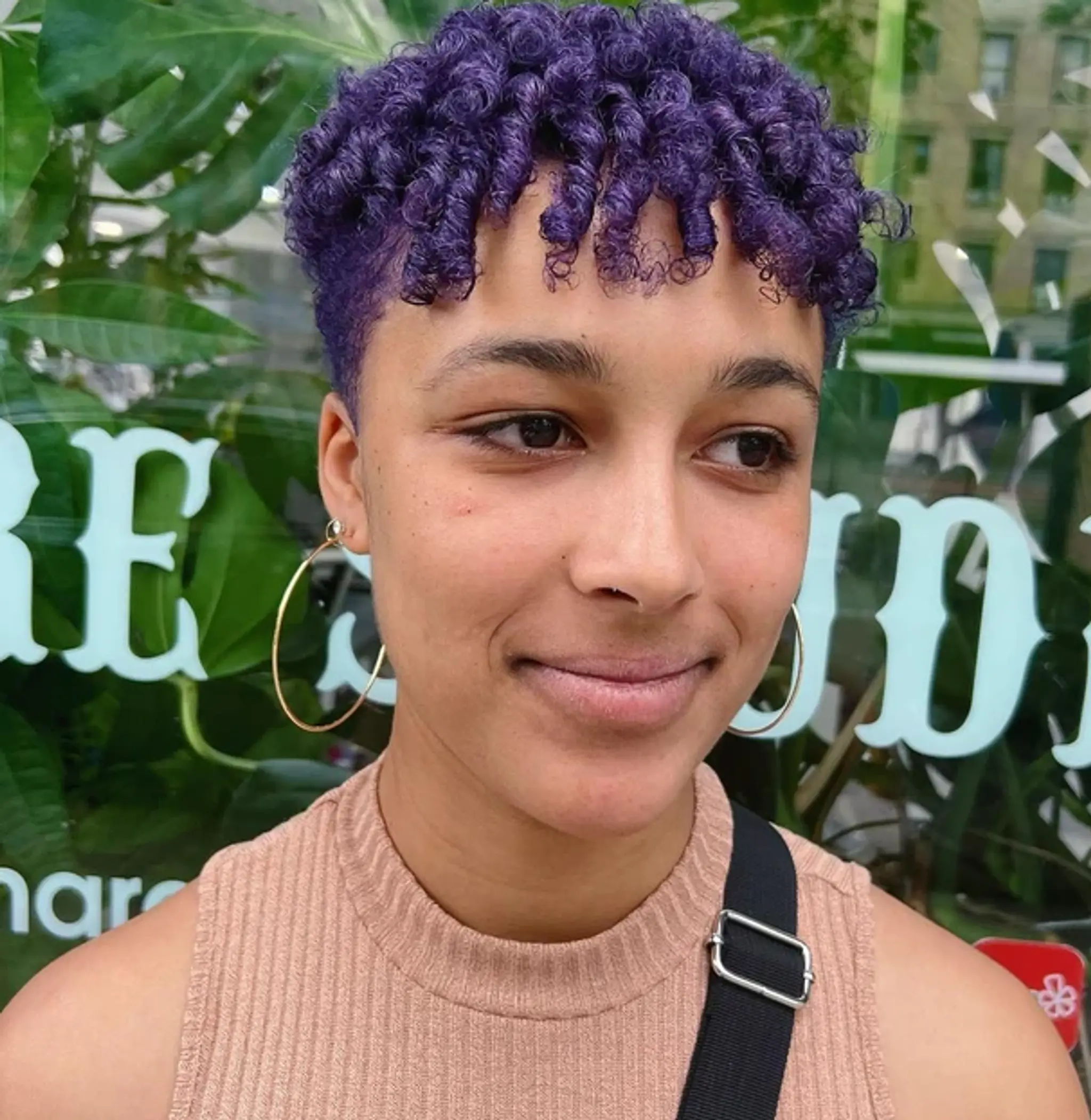 Short, coiled hair dyed in a vibrant purple color with well-defined coils forming curly bangs.