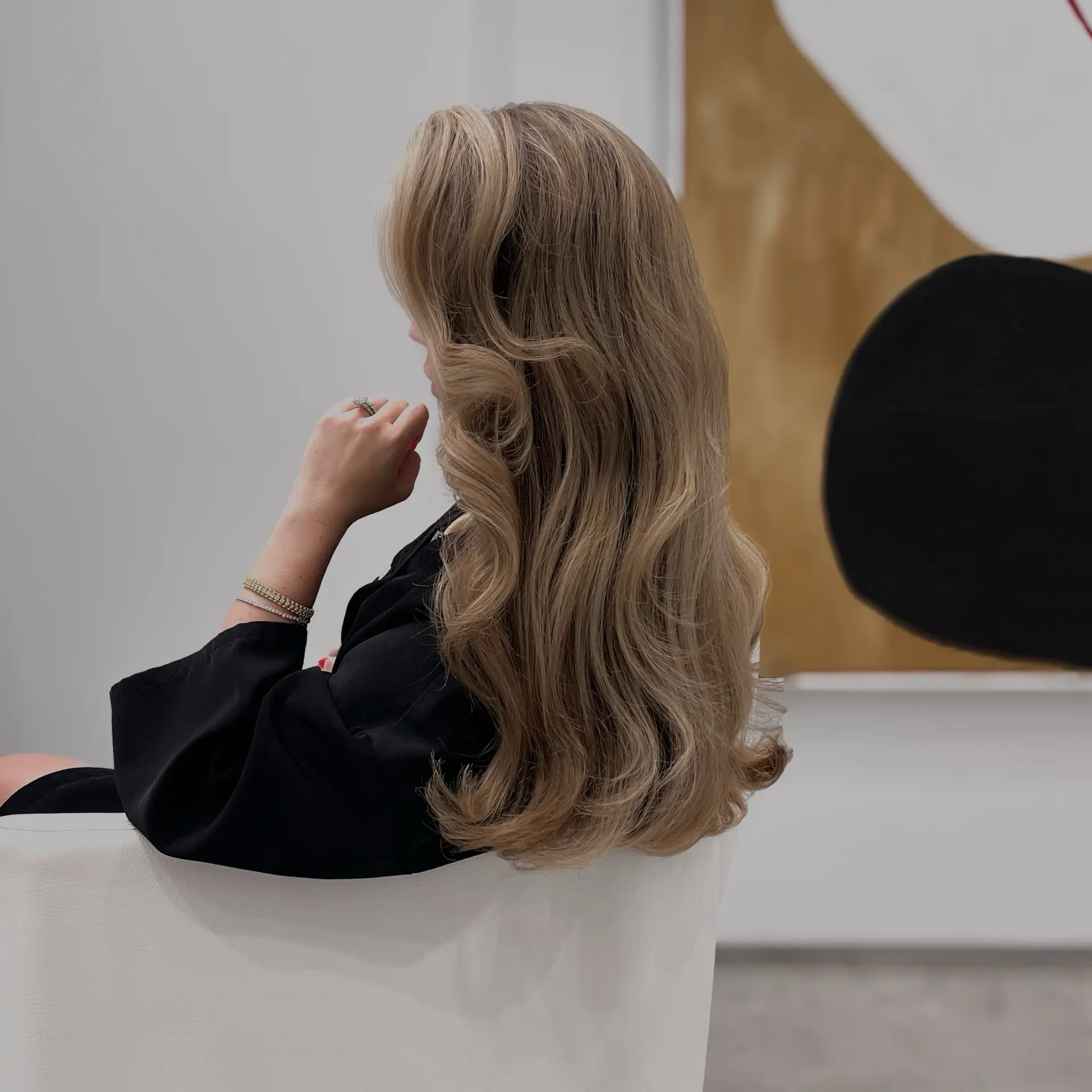 Long, flowing ash blonde hair styled in a bouncy, voluminous brushed-out blowout. 1