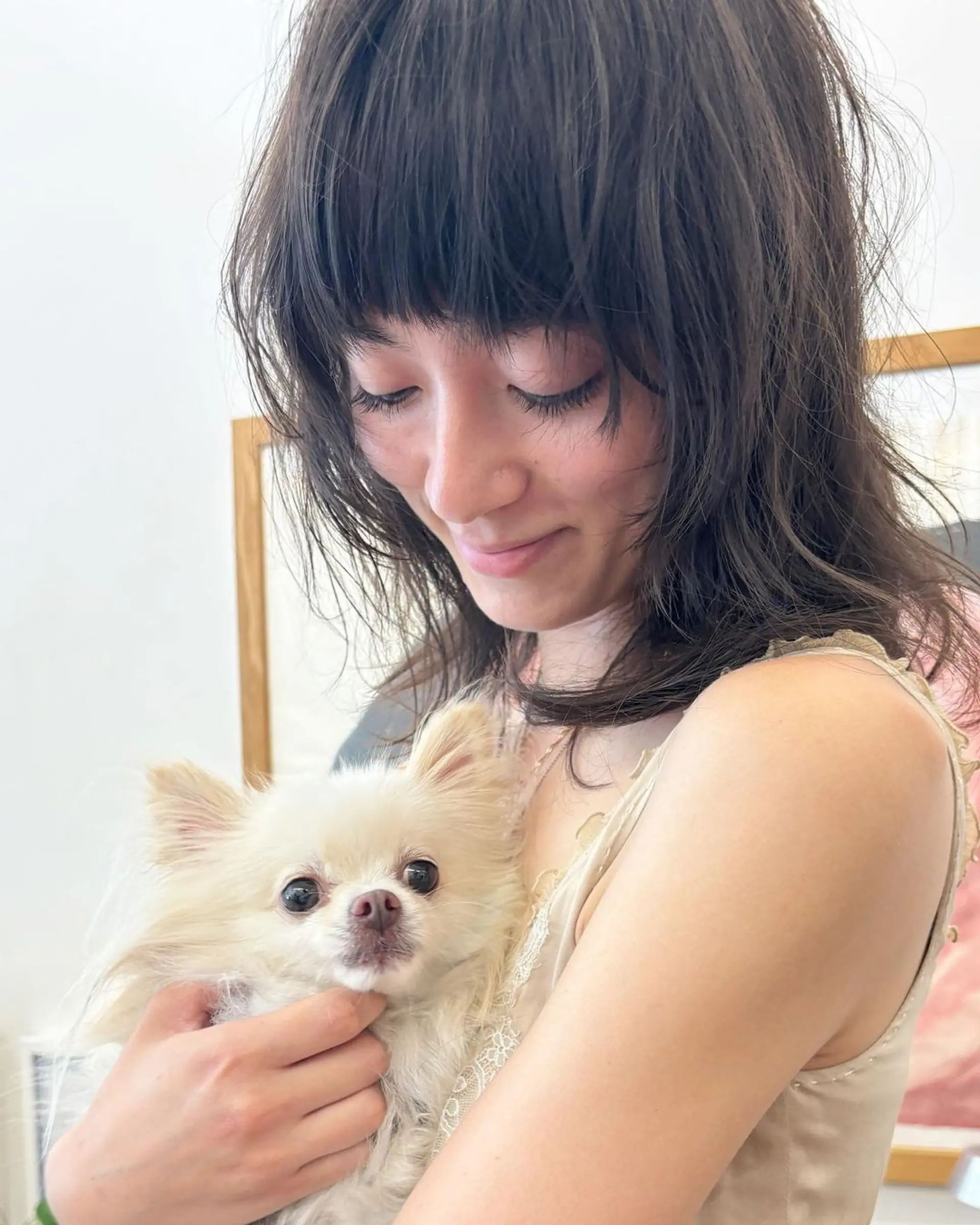 A medium-length, wavy dark brown hairstyle with textured, tousled layers, a shaggy cut, and blunt bangs. 3