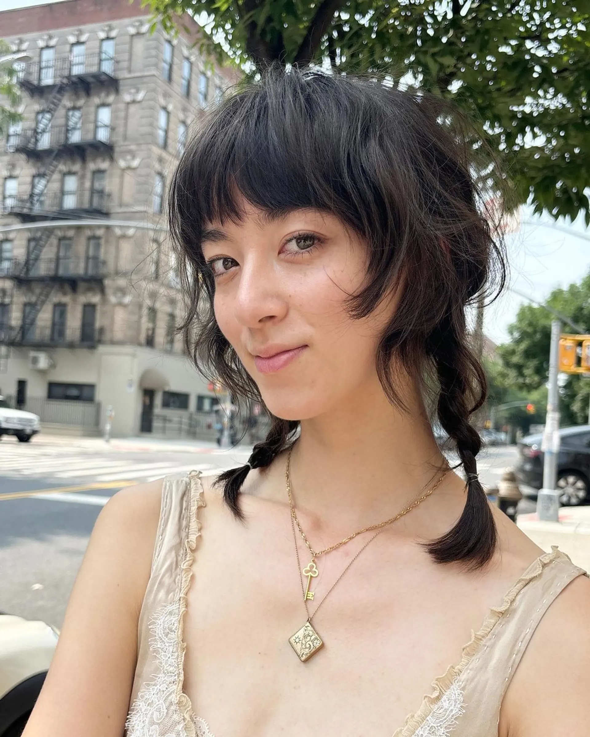 A medium-length, wavy dark brown hairstyle with textured, tousled layers, a shaggy cut, and blunt bangs. 4