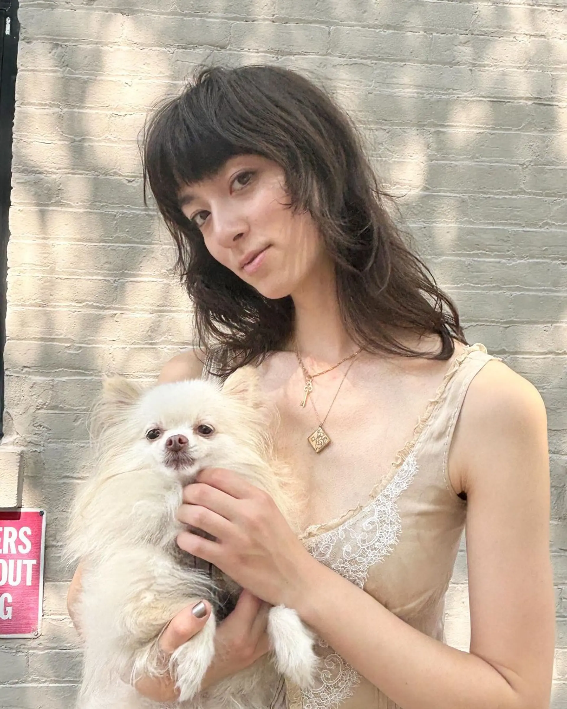 A medium-length, wavy dark brown hairstyle with textured, tousled layers, a shaggy cut, and blunt bangs. 2