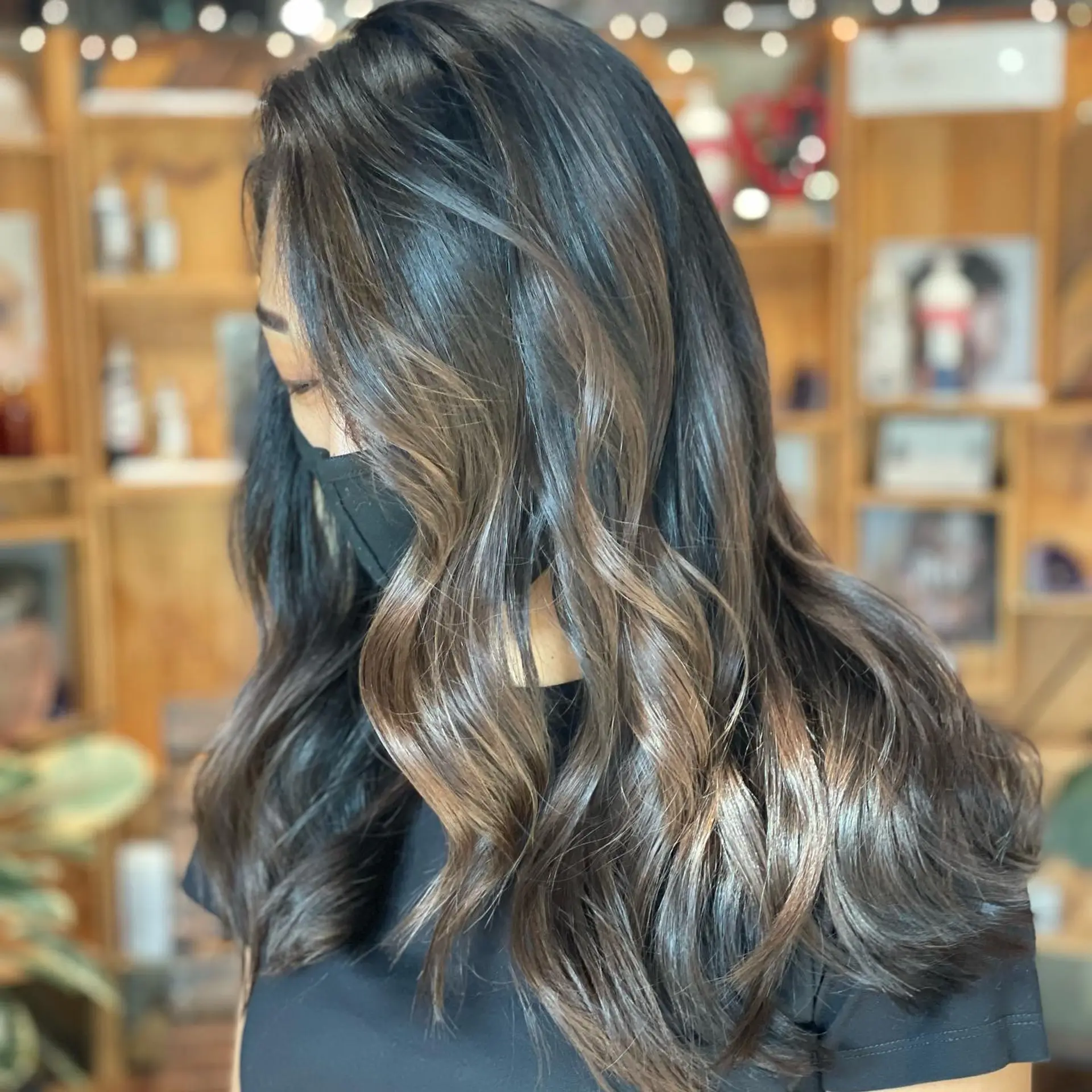 Long dark brunette hair styled in glossy, loose waves with subtle dimensional balayage highlights. 1