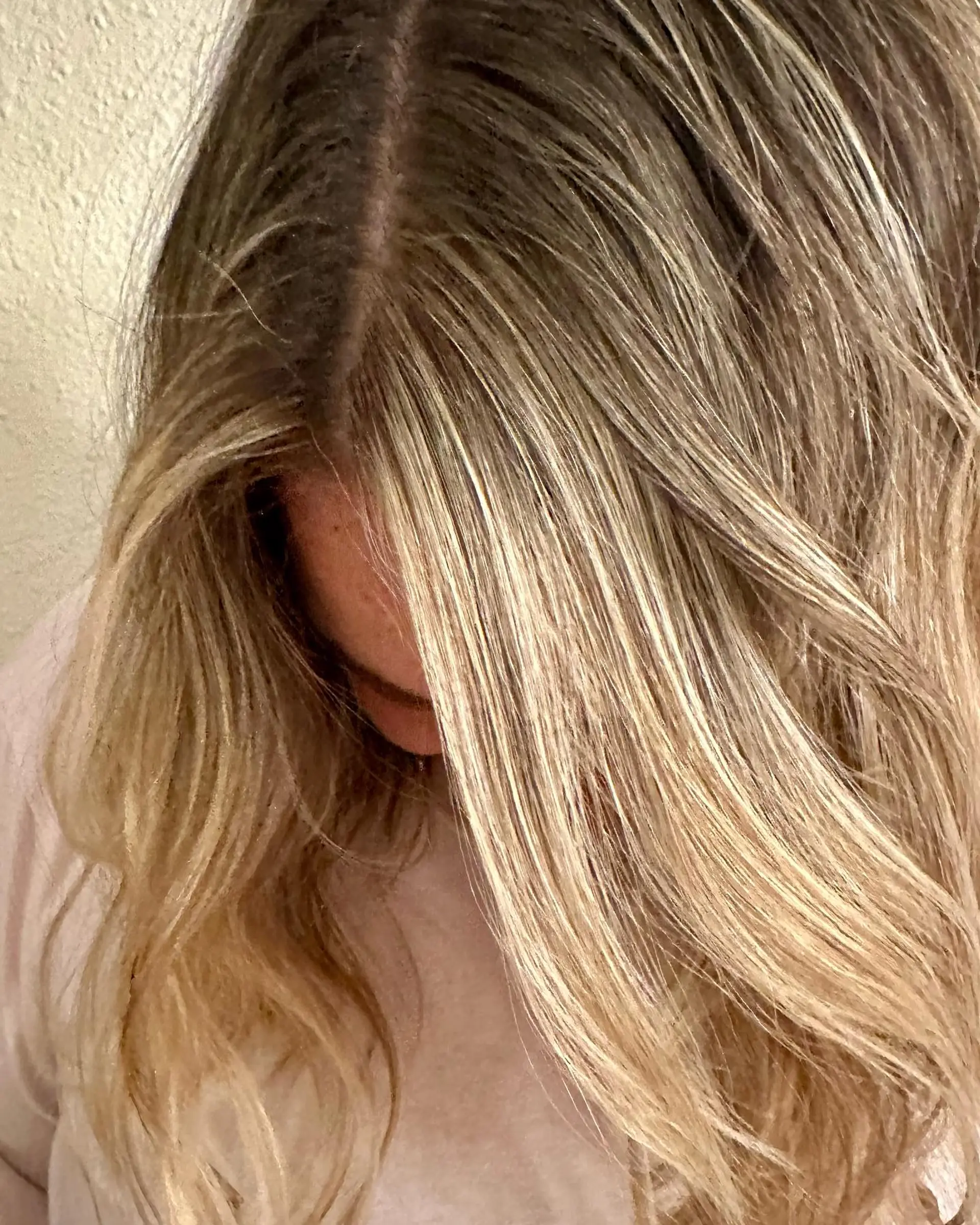 Dimensional beige blonde foilyage with a blended root and soft wavy texture. 1