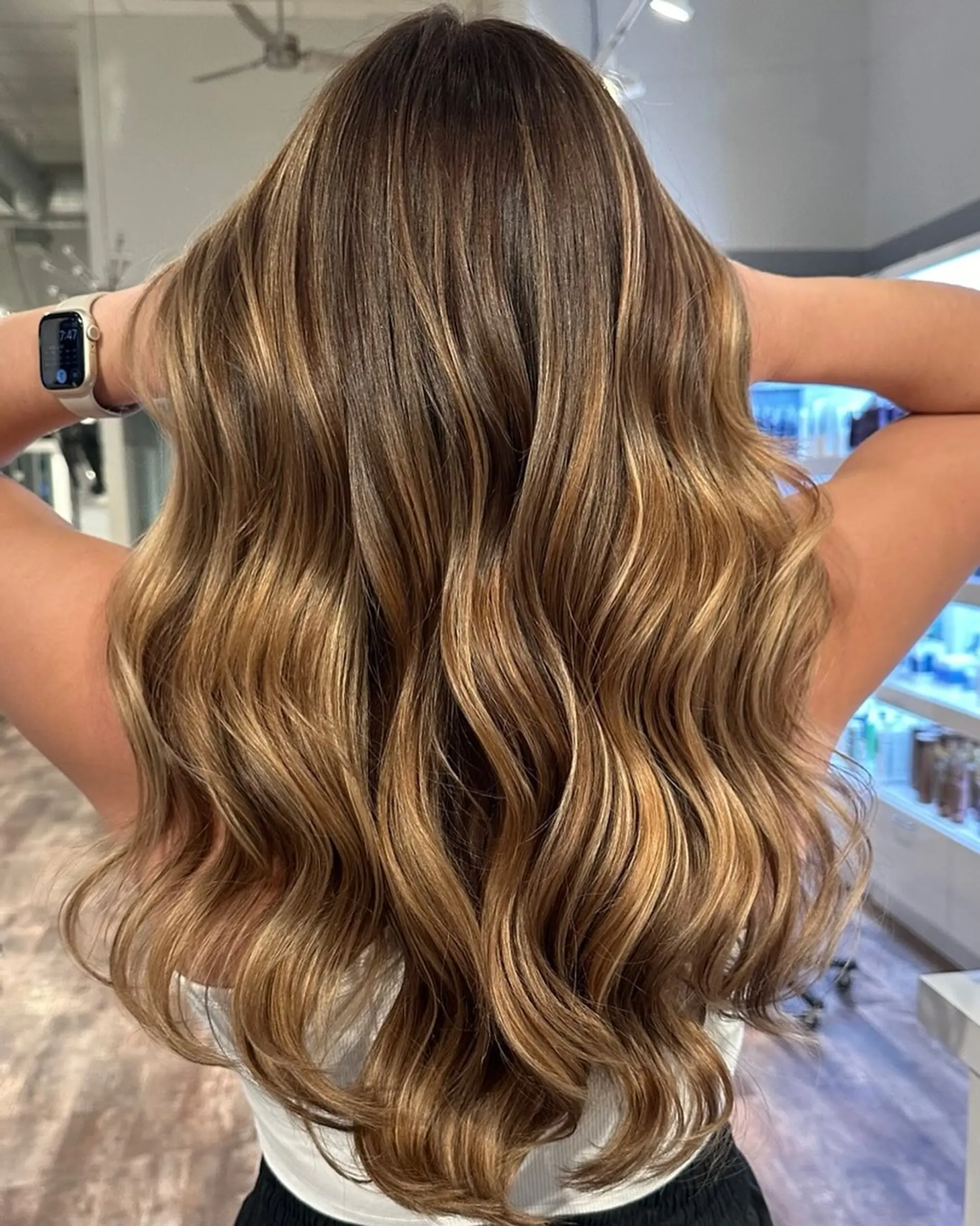 Long, wavy hair with a caramel honey balayage and dark roots. 1