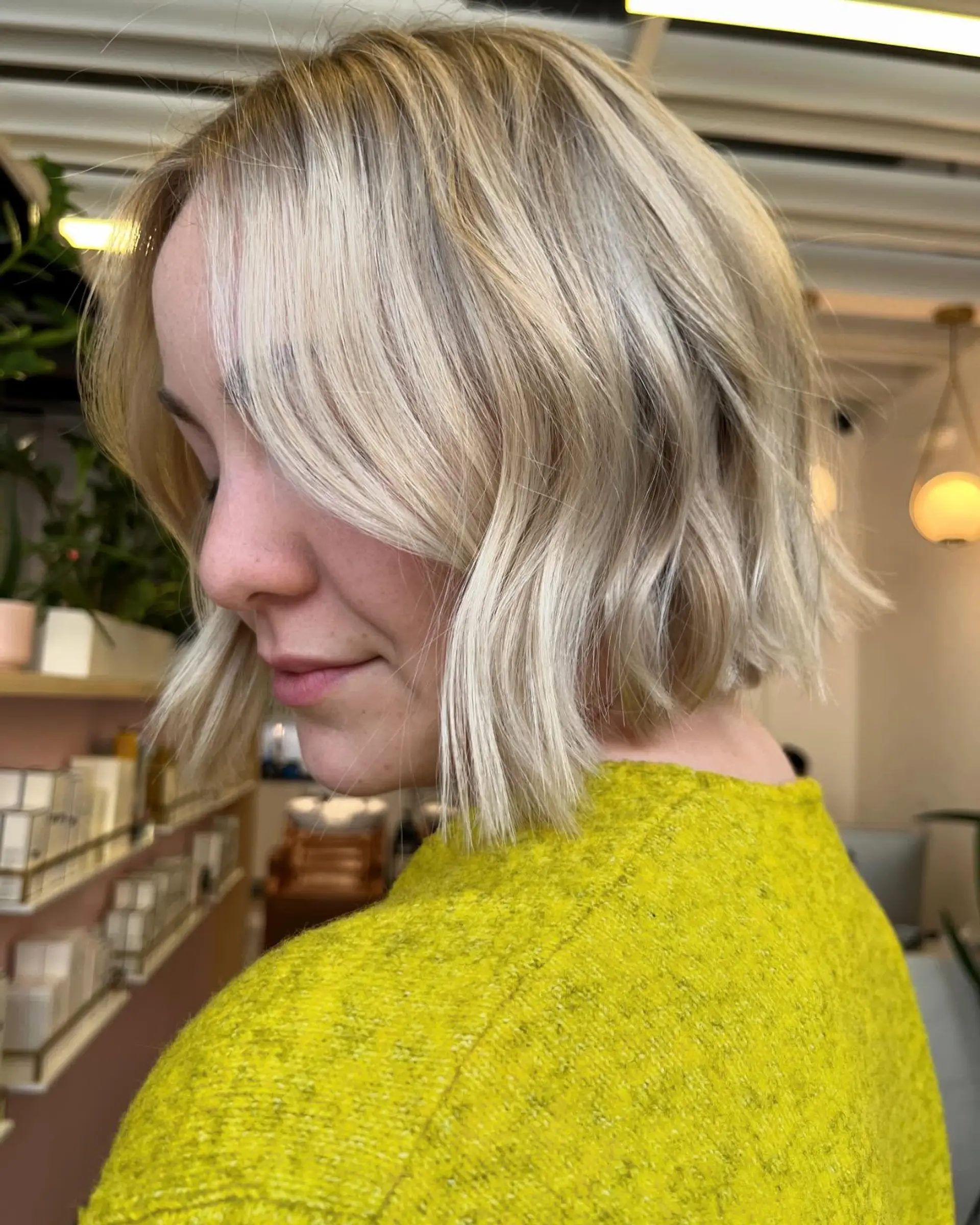 A textured short blonde bob styled with gentle waves and soft face-framing layers. 1