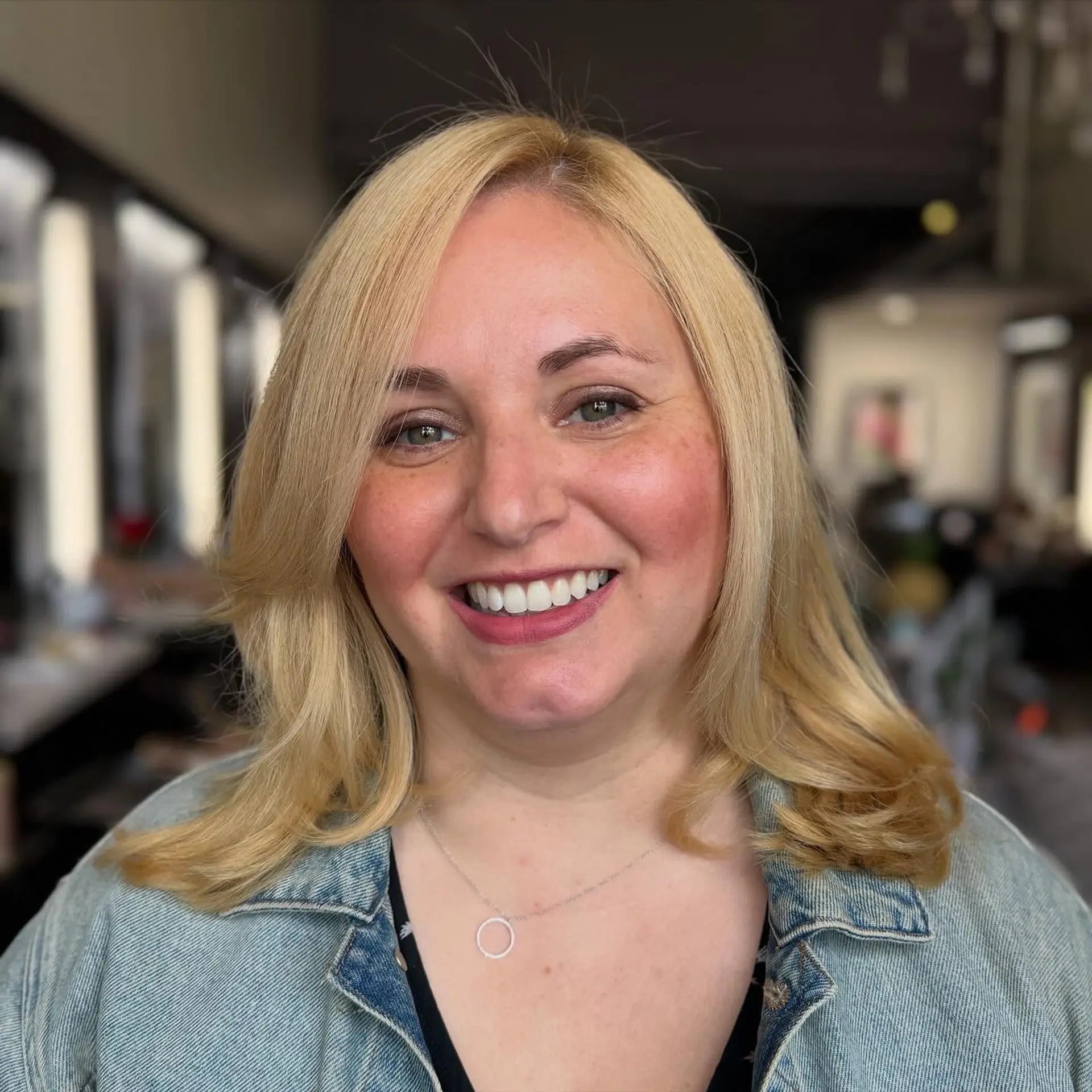 Shoulder-length blonde hair cut with soft face-framing layers and flipped ends. 1