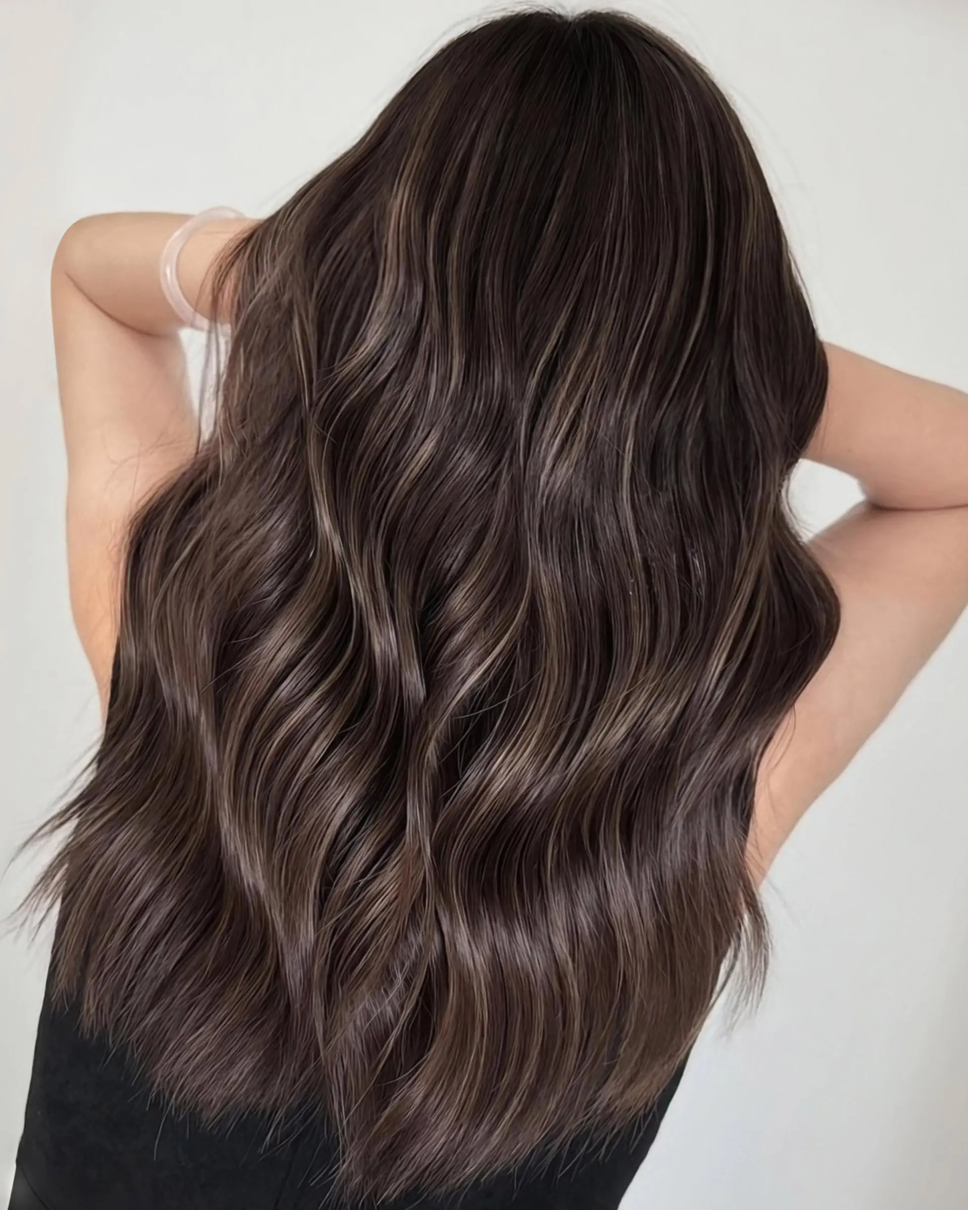 A long, wavy ash brown balayage with subtle highlights. 1
