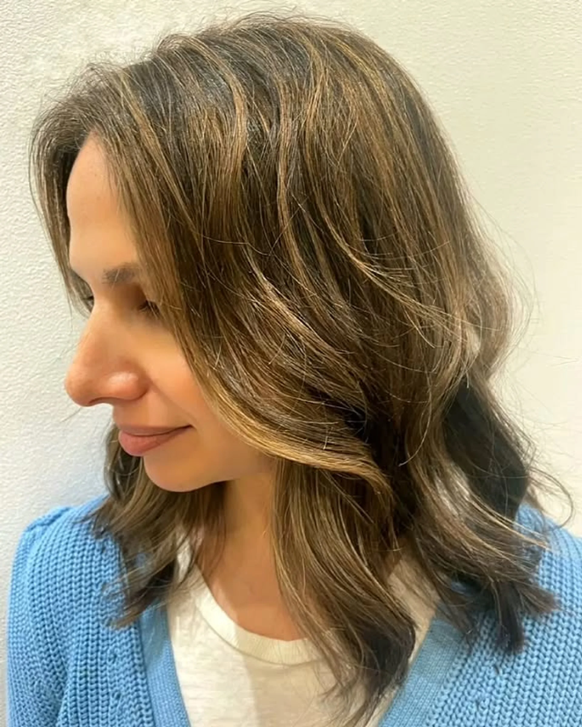 A man with medium-length wavy brown hair styled in a relaxed bro flow surfer hairstyle, demonstrating a key 2025 trend. - Preview 2