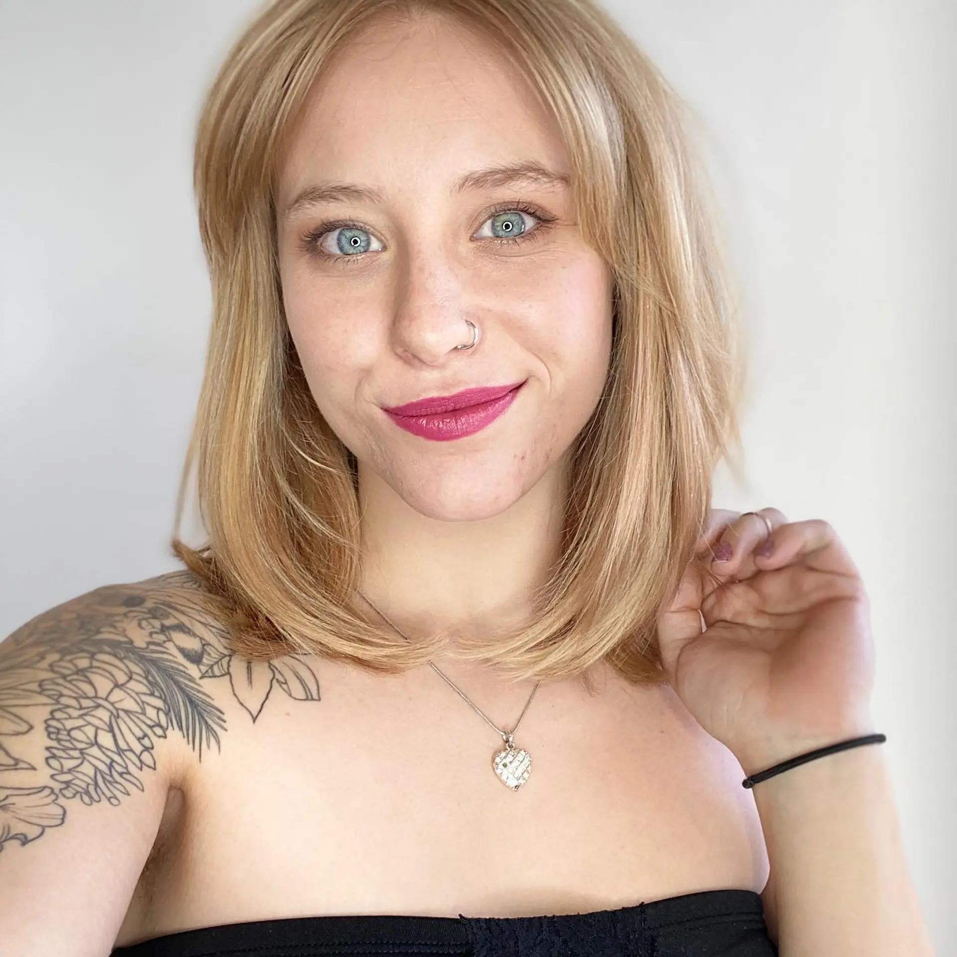 A sleek shoulder-length golden blonde lob styled with soft, inward-curving ends and face-framing curtain bangs. 1