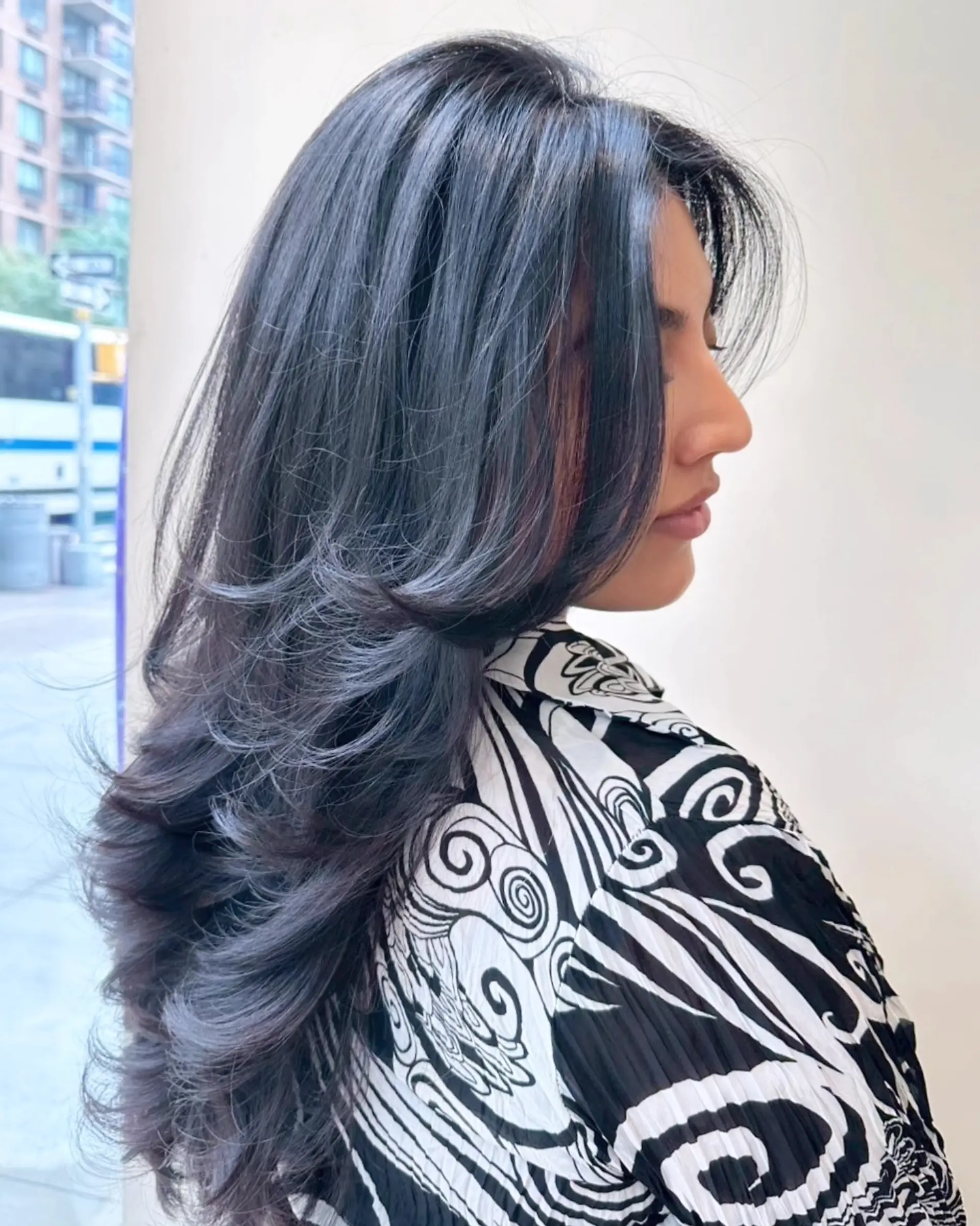 A long, voluminous haircut featuring cascading, feathered layers styled with sweeping curved ends and face-framing sections. 1