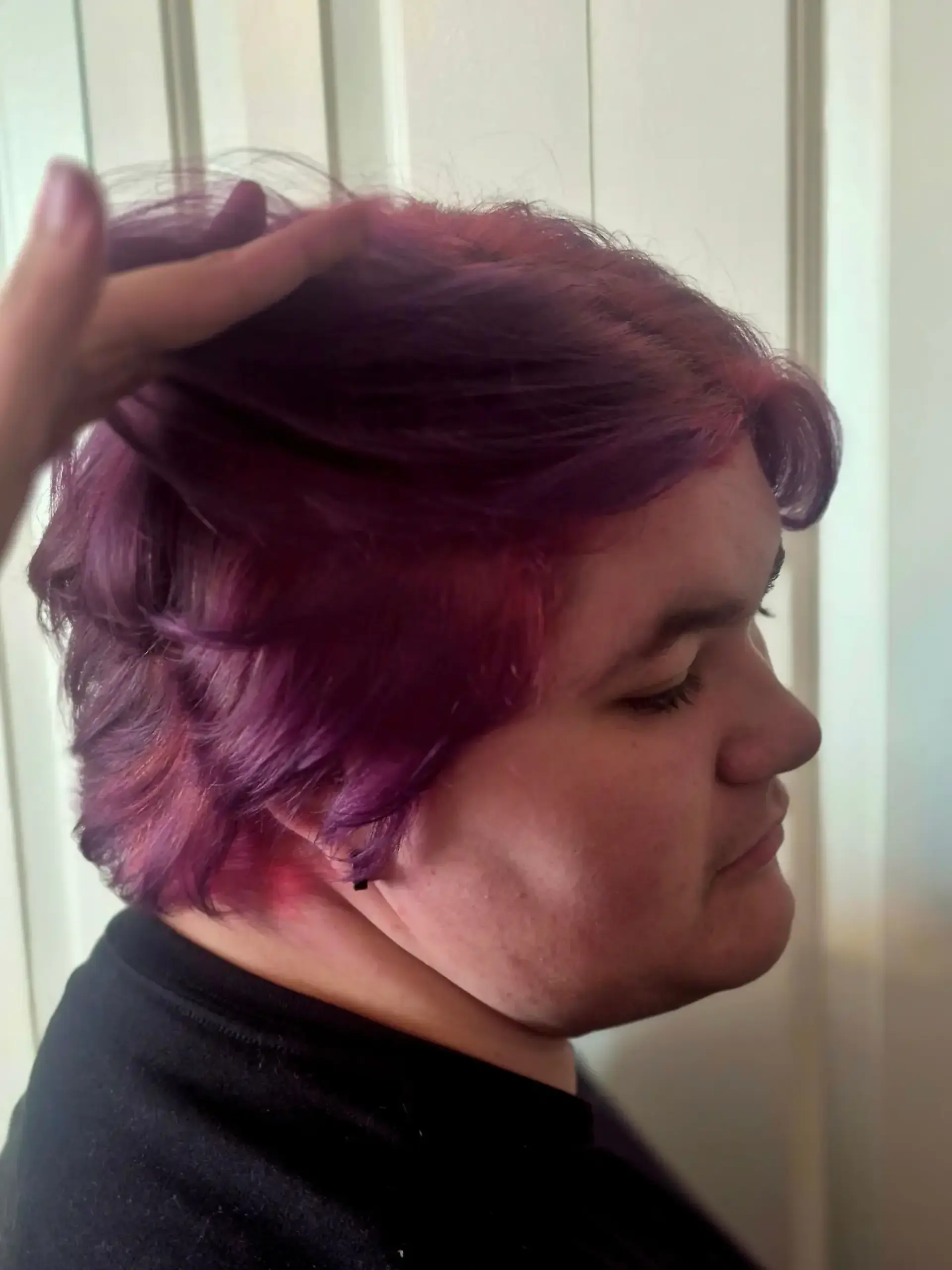 A short layered cut colored in deep purple with bright pink ghost roots revealed beneath. 1