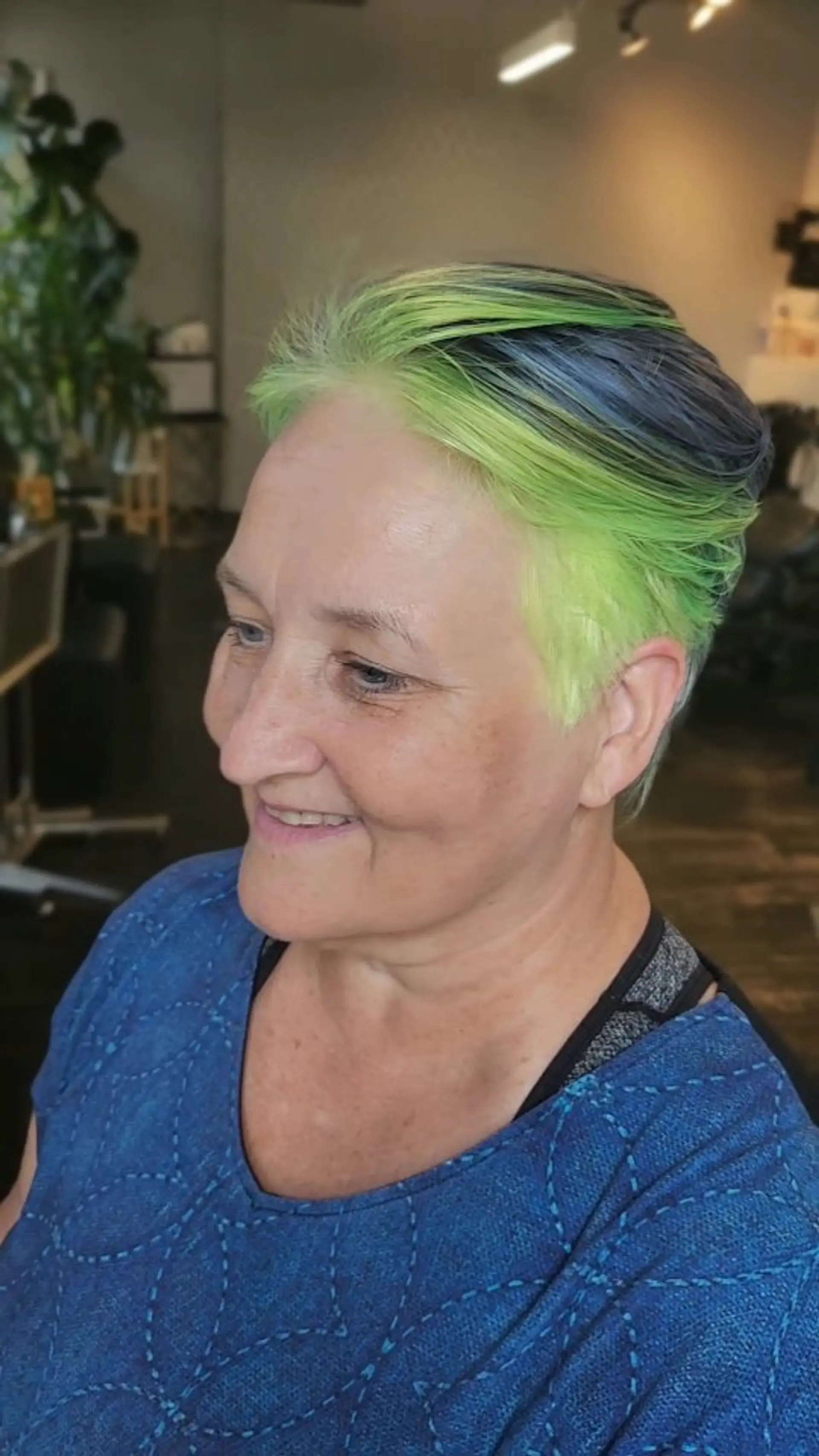 A sleek, vibrant short pixie cut featuring an electric neon lime green front faded into dark slate blue tones. 1
