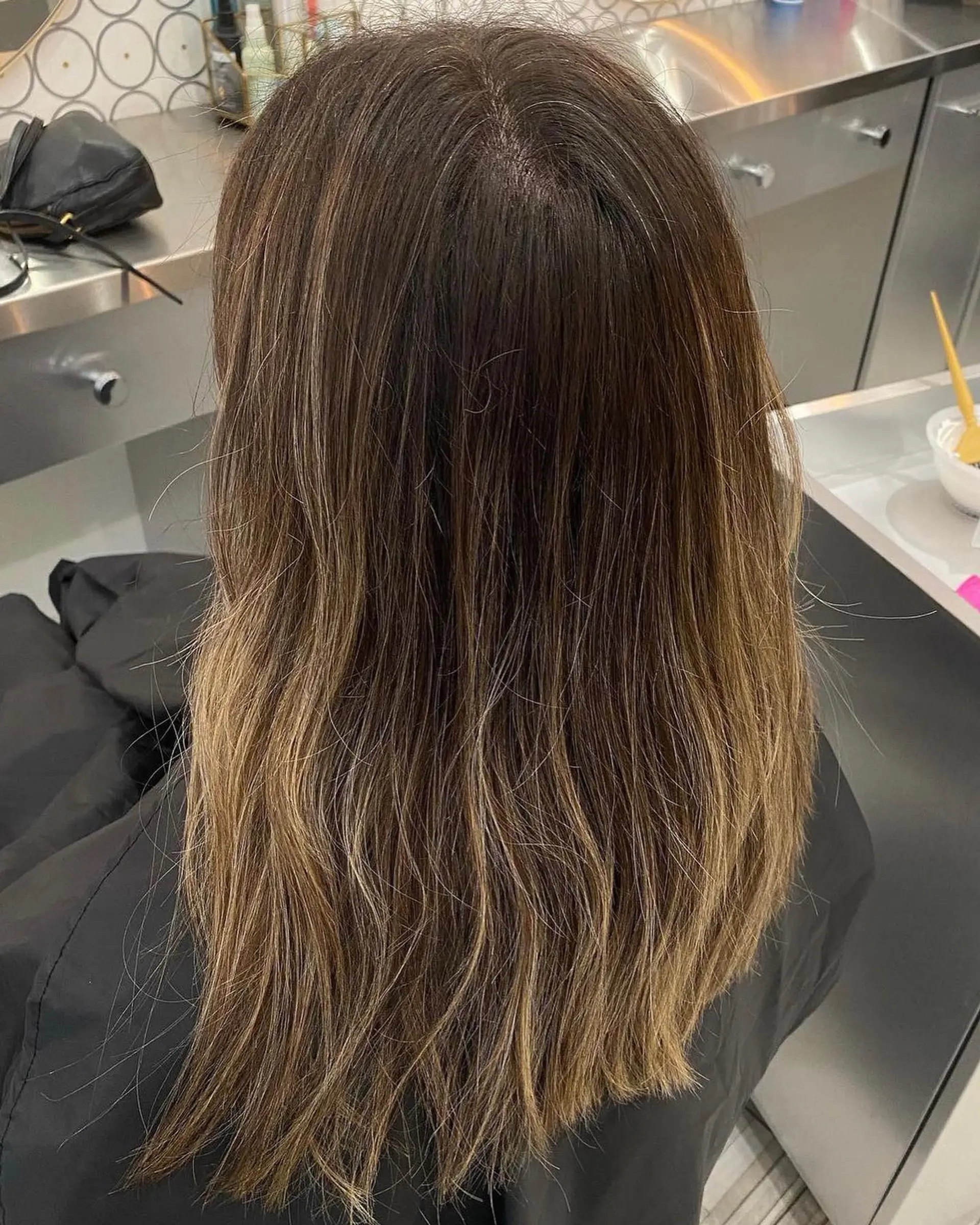Natural bronde balayage seamlessly blending brunette base tones with soft golden blonde highlights on long hair. 1