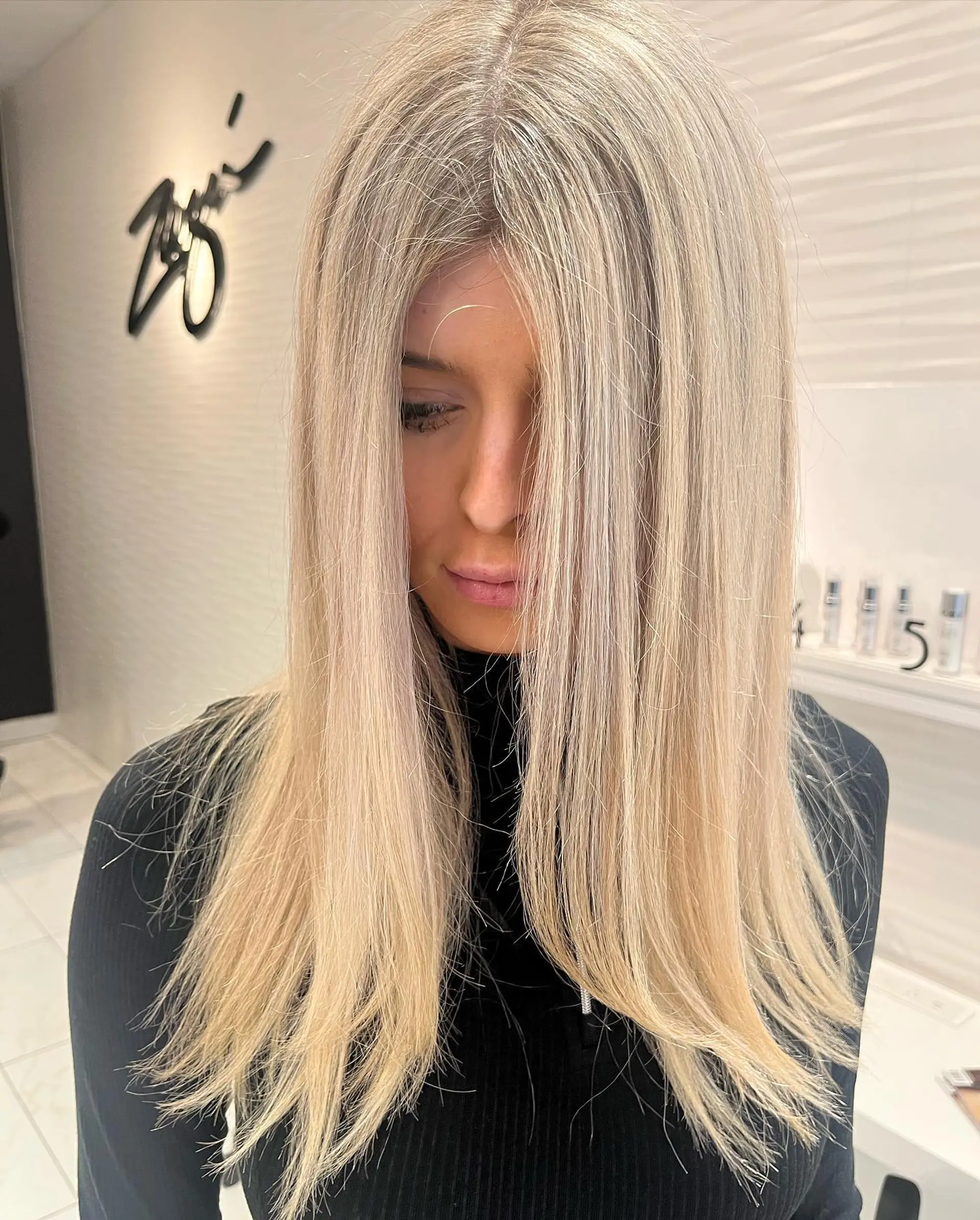 Long, straight hair with an icy platinum blonde color and face-framing layers. 1